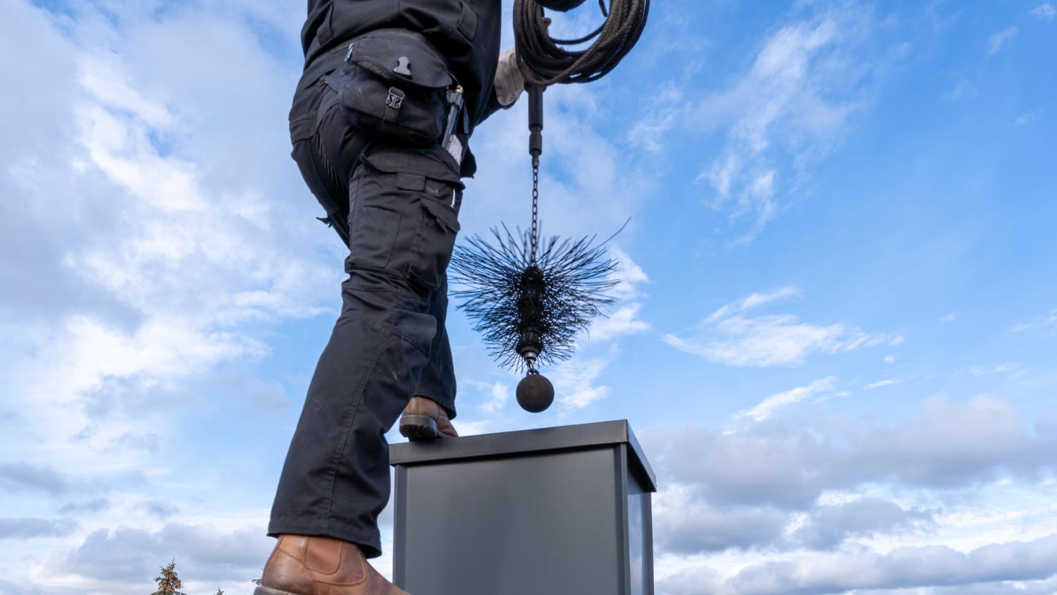 Chimney sweep cleaning a chimney