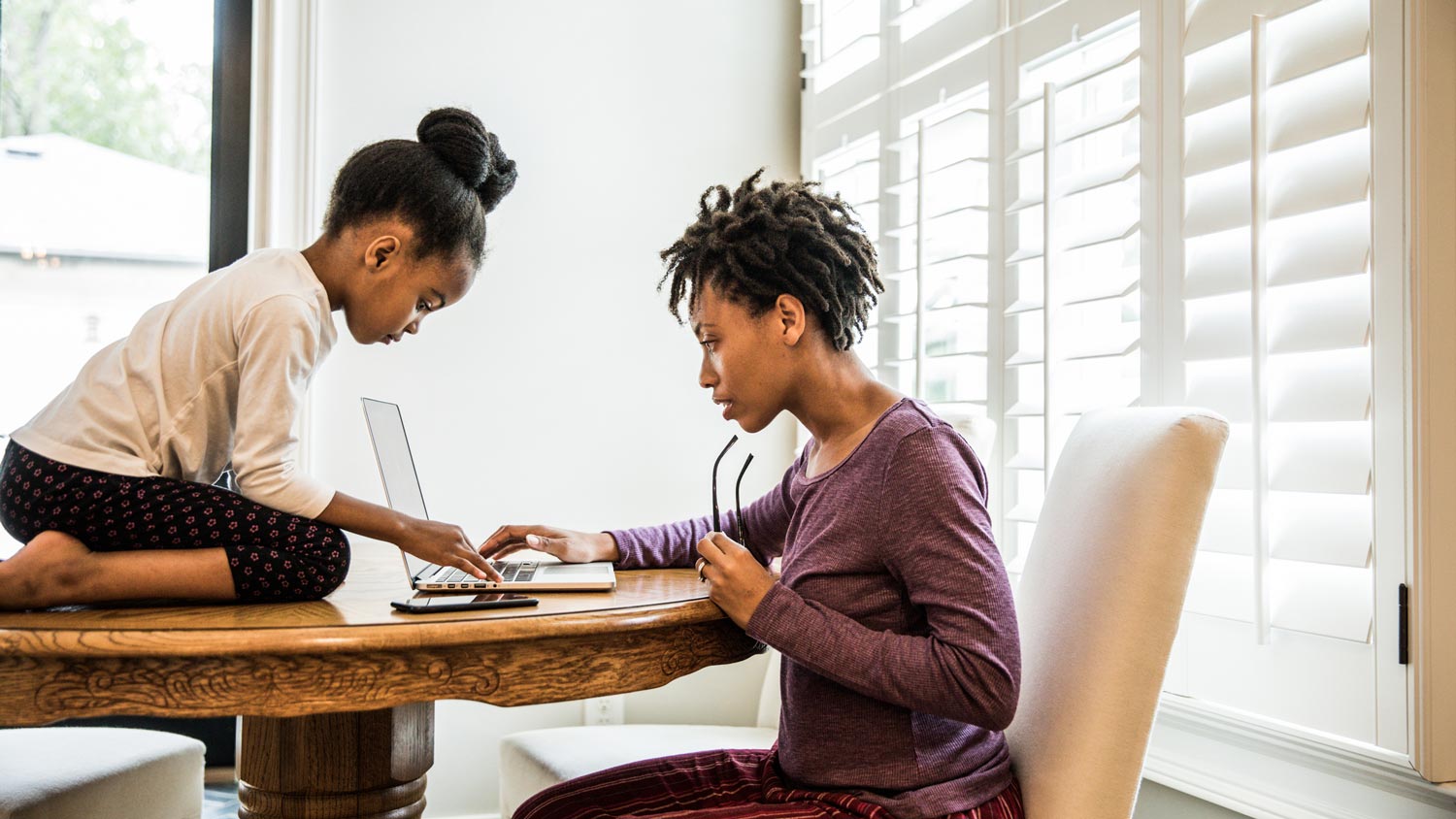 Daughter and mother searching online on her laptop