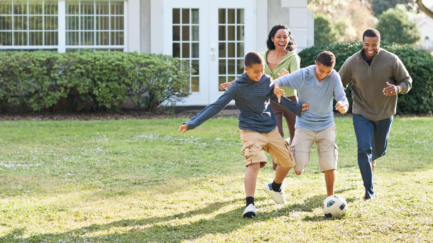 Family playing soccer in their backyard