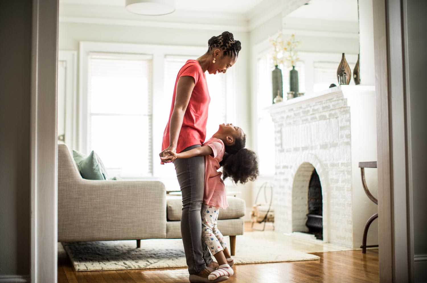 Little girl standing on mothers feet