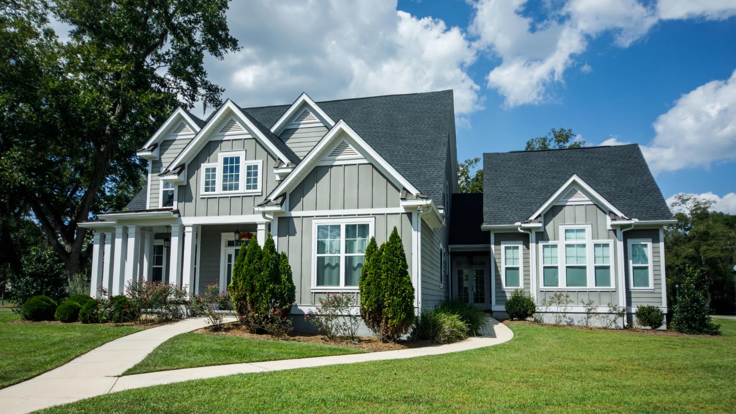 A house with hardy board siding on a large lot with a green lawn