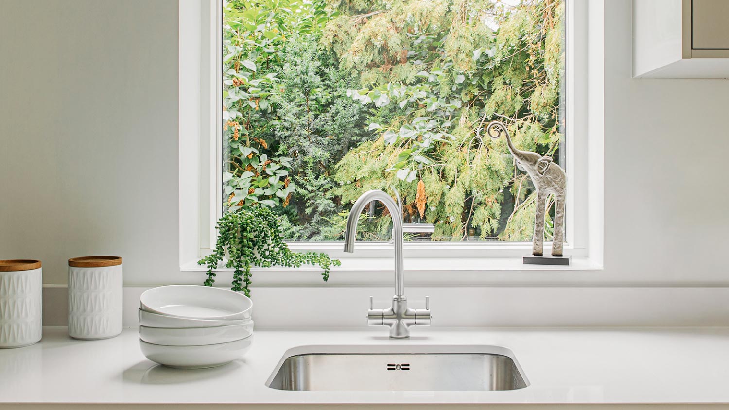 A kitchen sink with a nature view