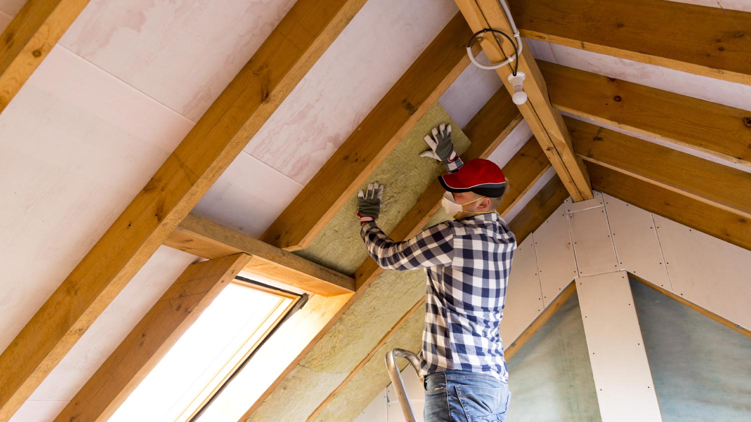 Man installing thermal roof insulation layer