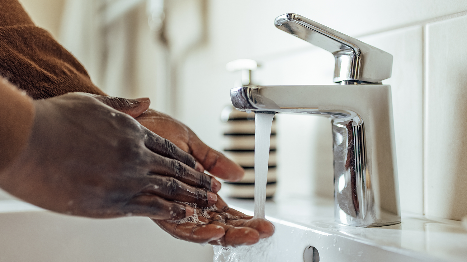 Man washing his hands in bathroom sink