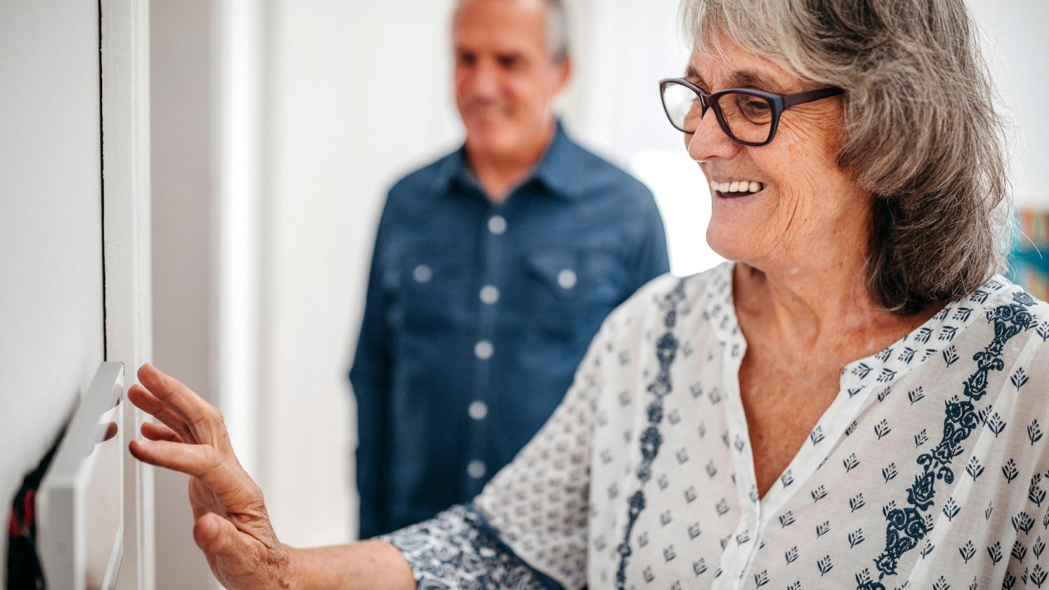 A senior woman using home automation touch screen