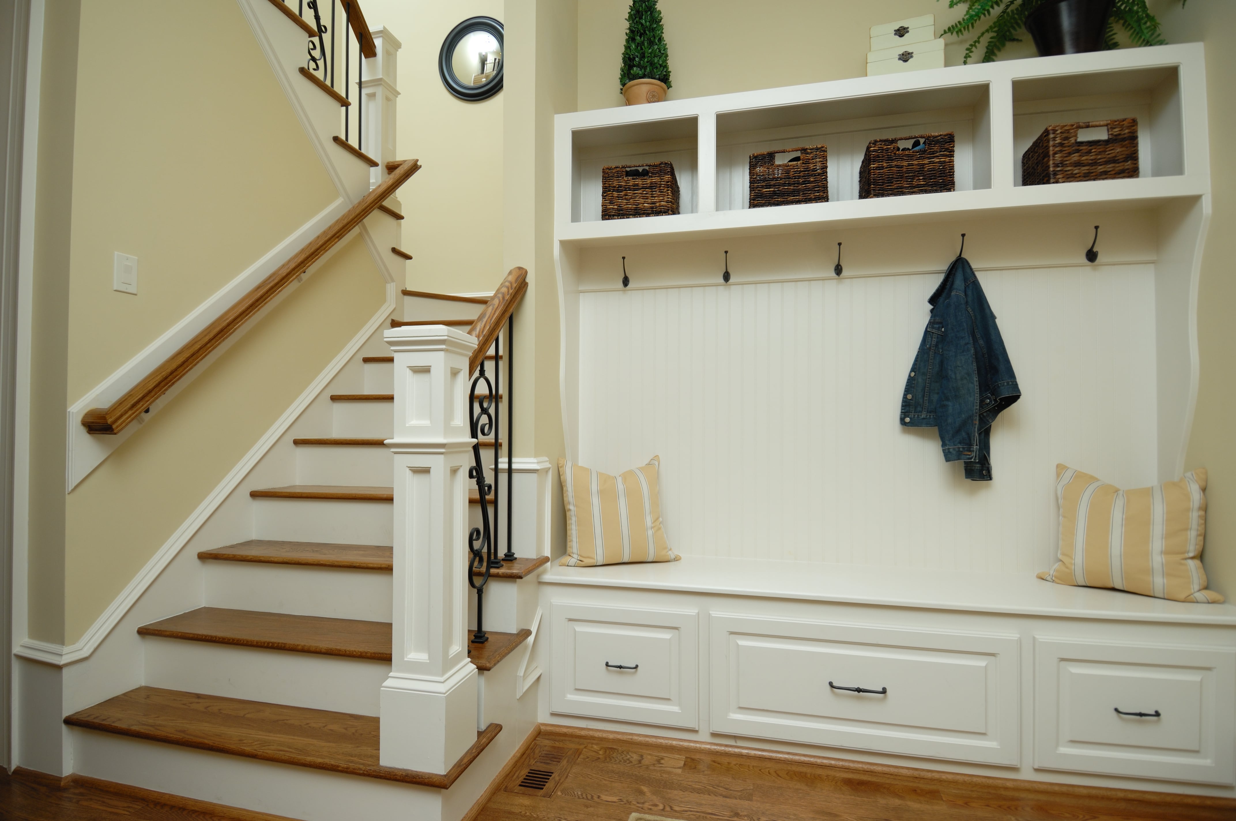 An interior staircase with a built-in coat rack at the base