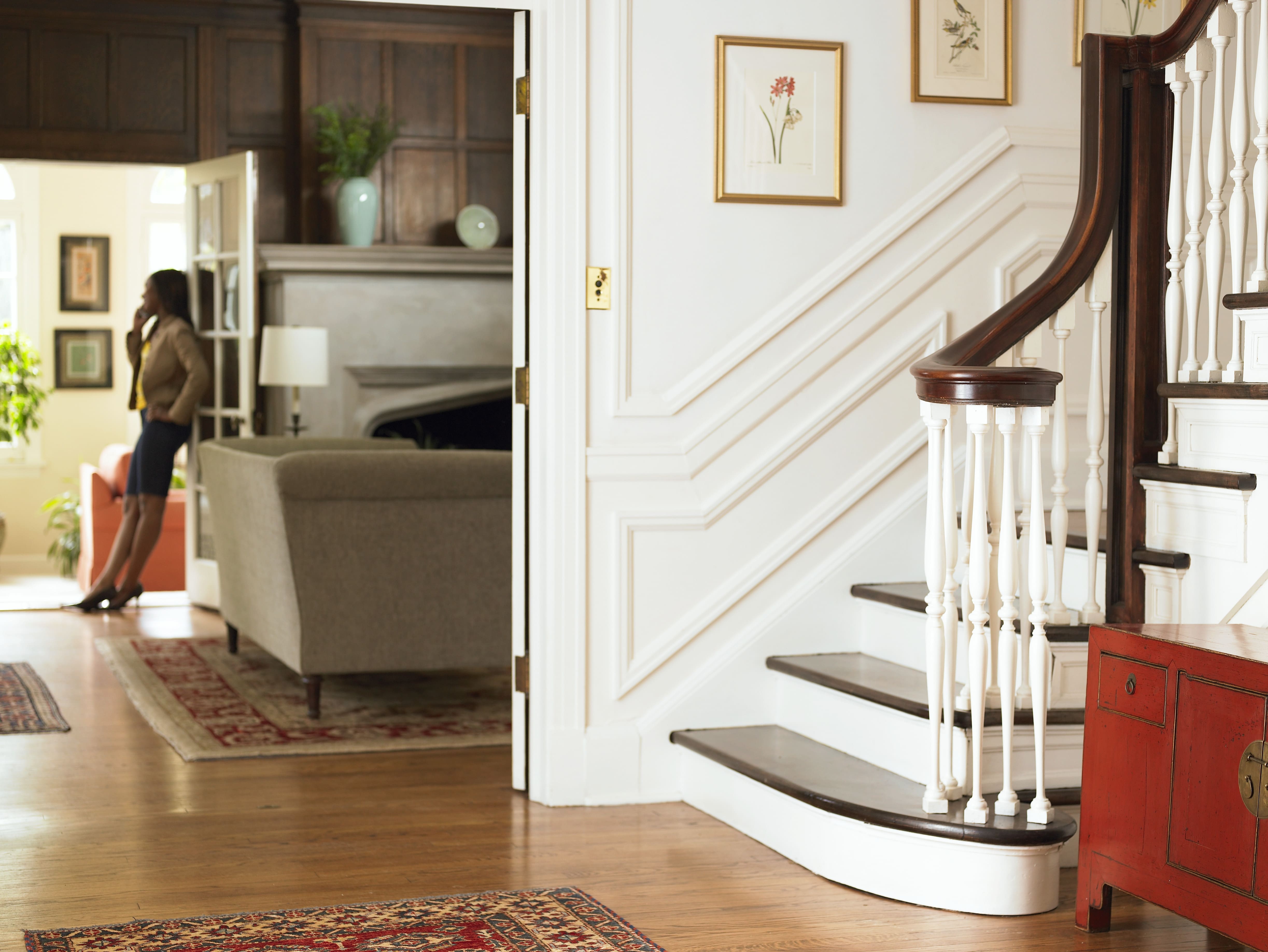 A classic interior stairwell decorated with minimalist flower prints in gold frames