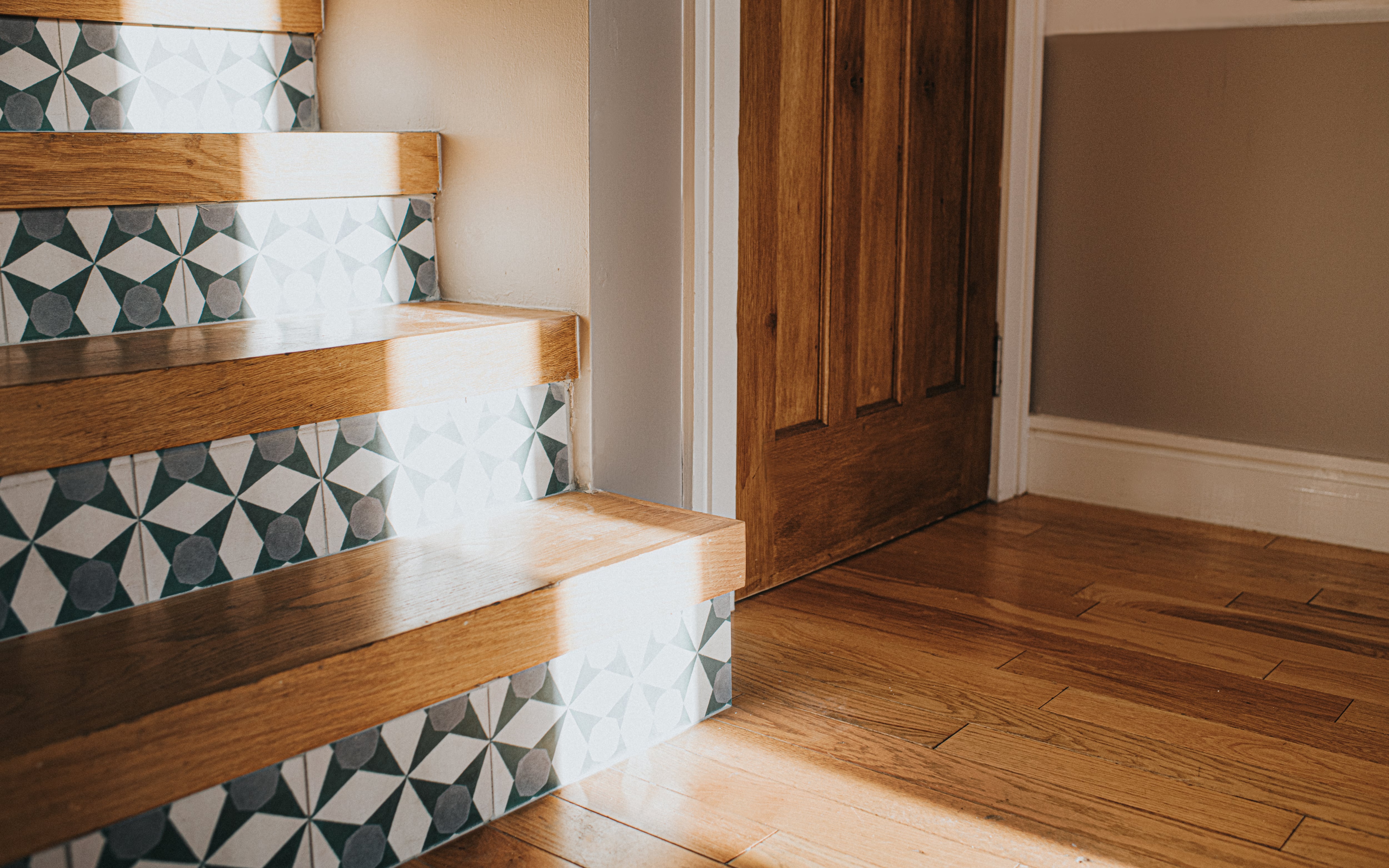 A wooden interior staircase with patterned tile stair risers