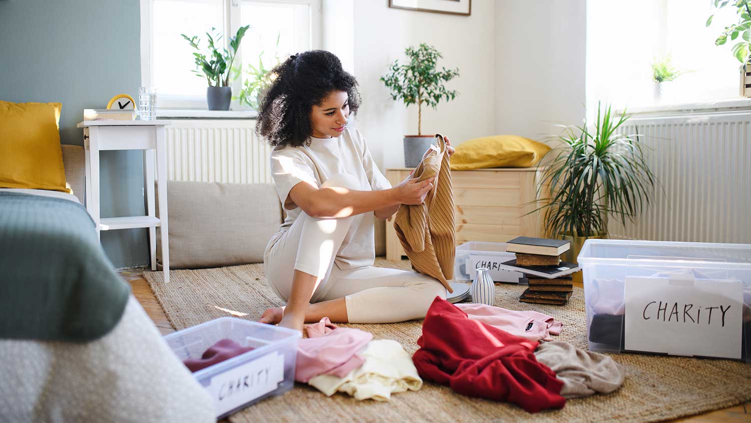 Woman cleaning bedroom and putting away clothes