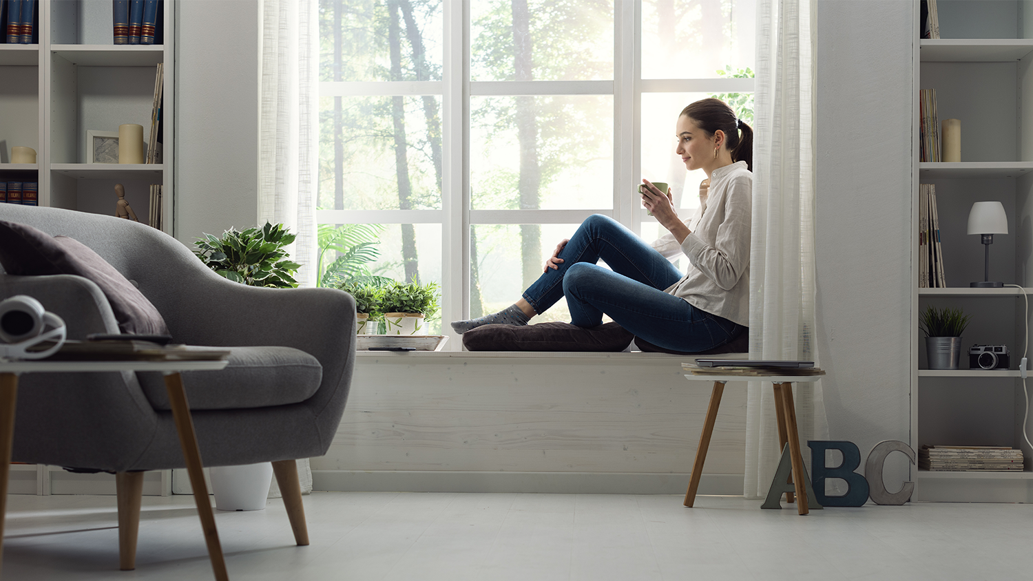 Woman sitting by window at home