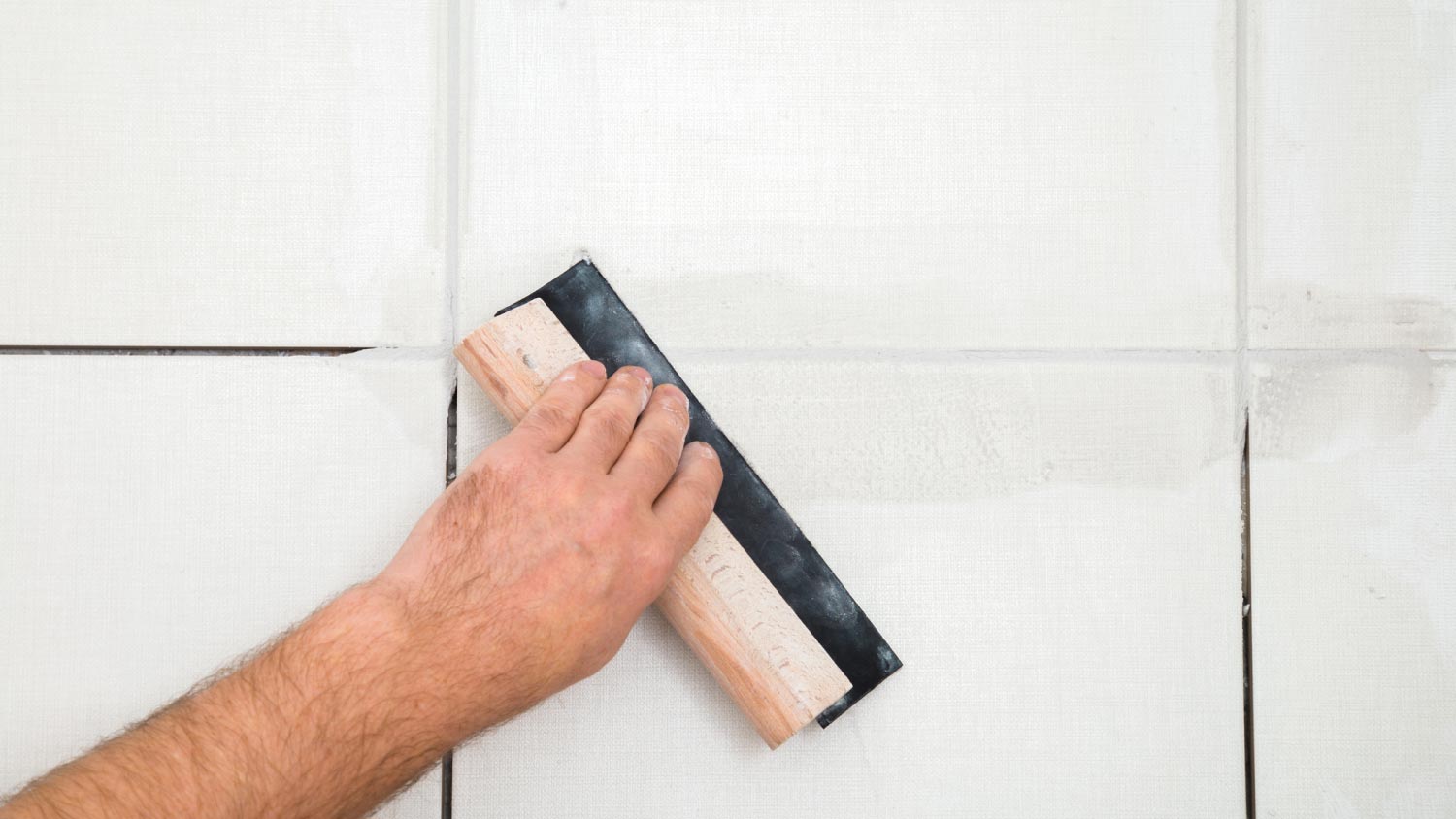 A worker hands using rubber trowel