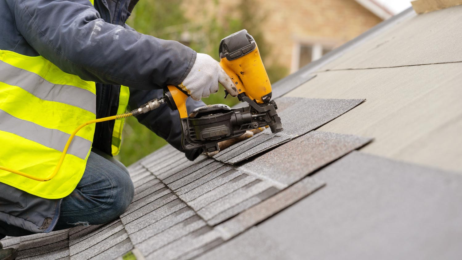 A worker installing a tile on roof