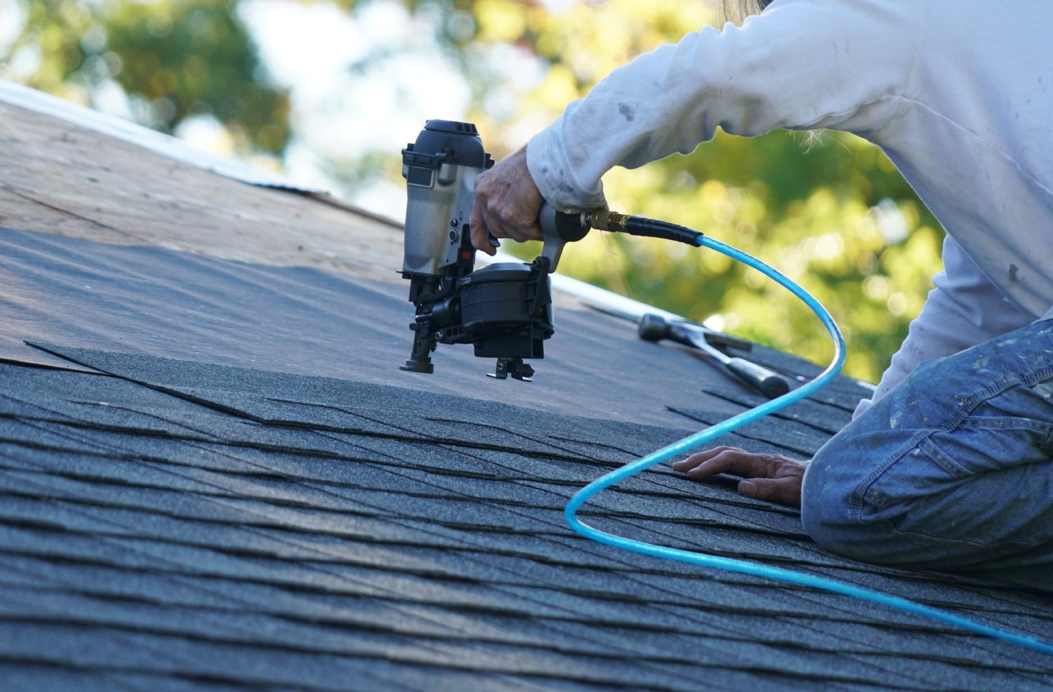 A worker using a nail gun