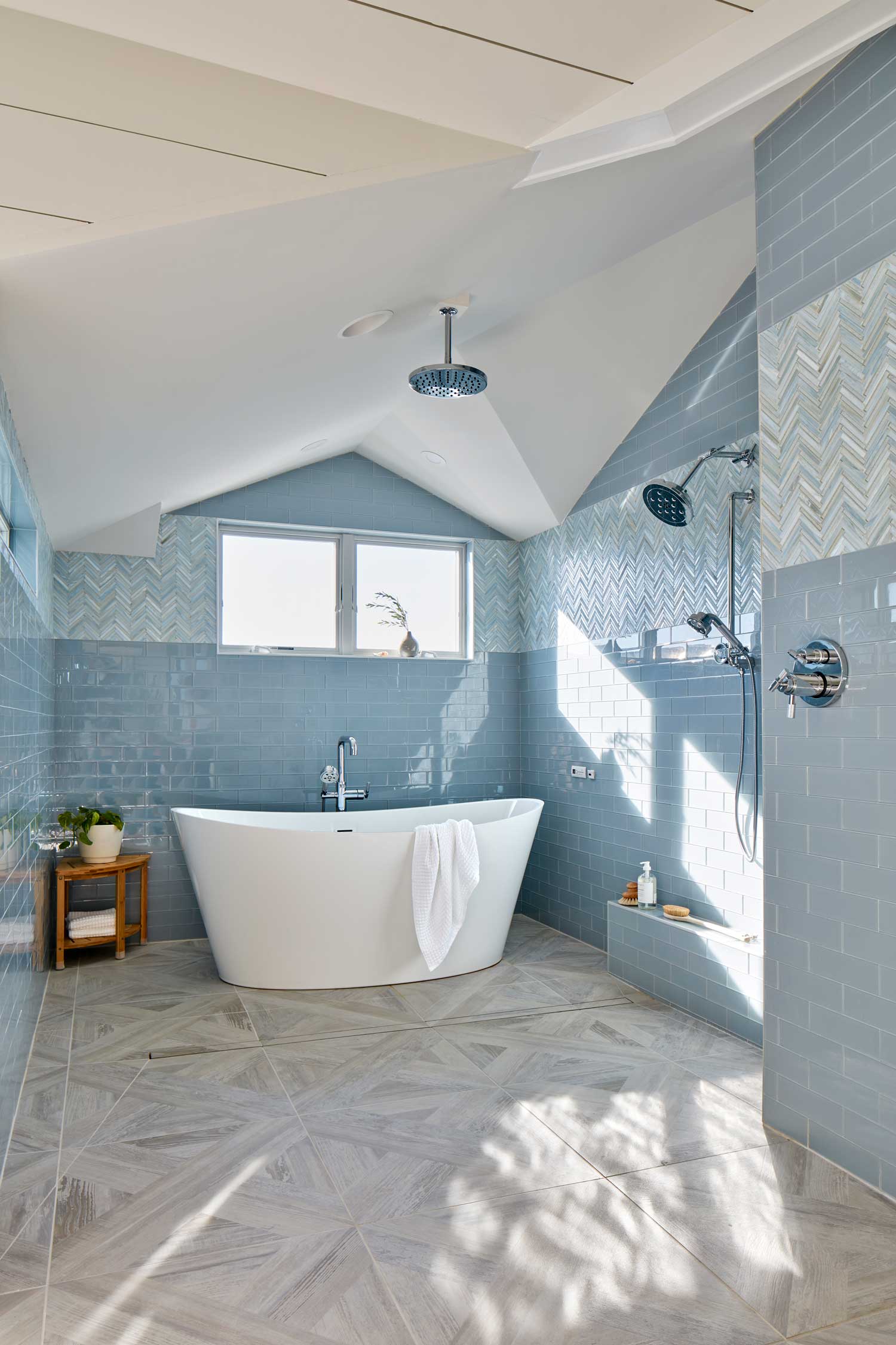 Spacious shower stall with bathtub and blue tiles