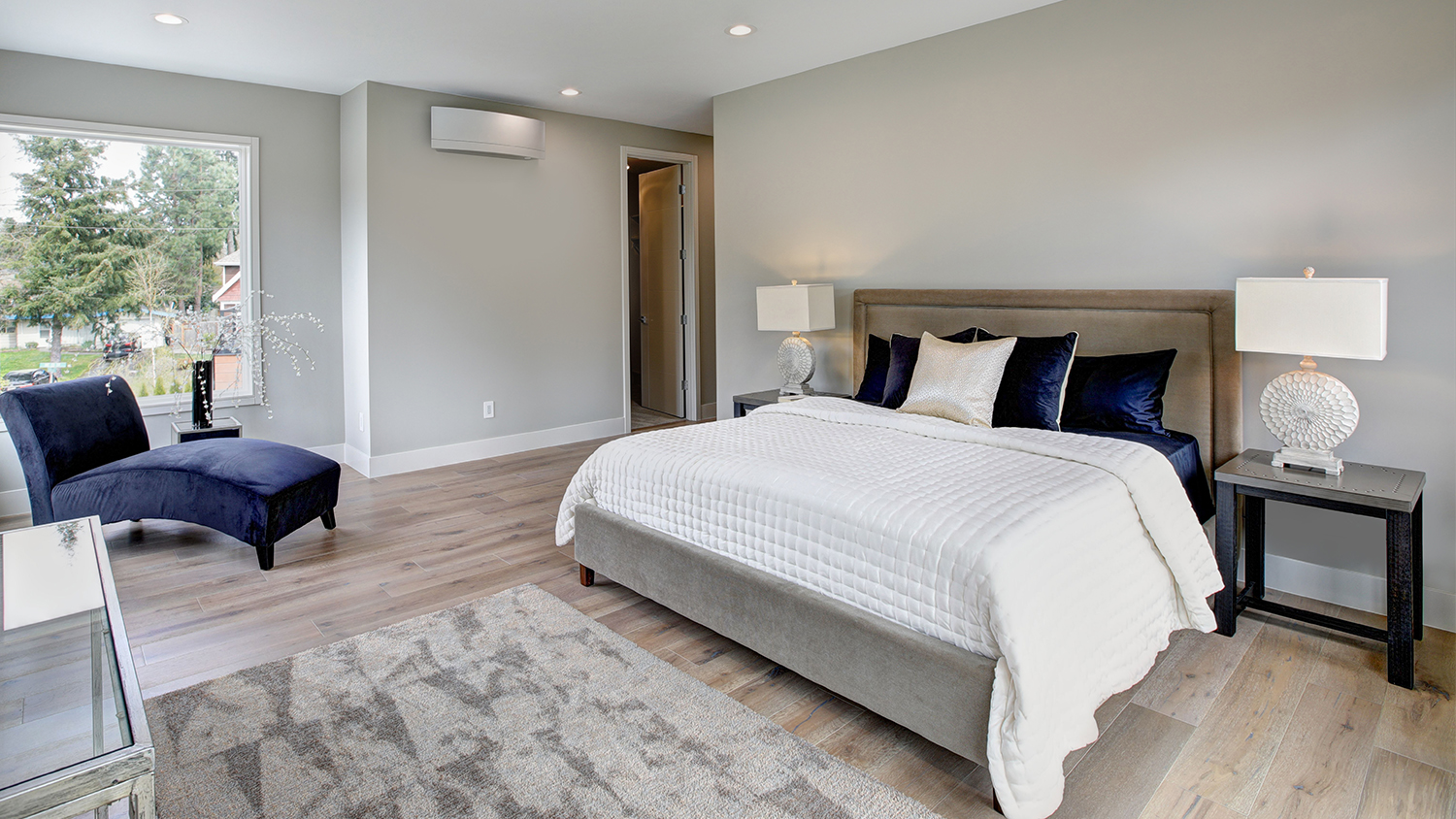 airy master bedroom with gray furniture 