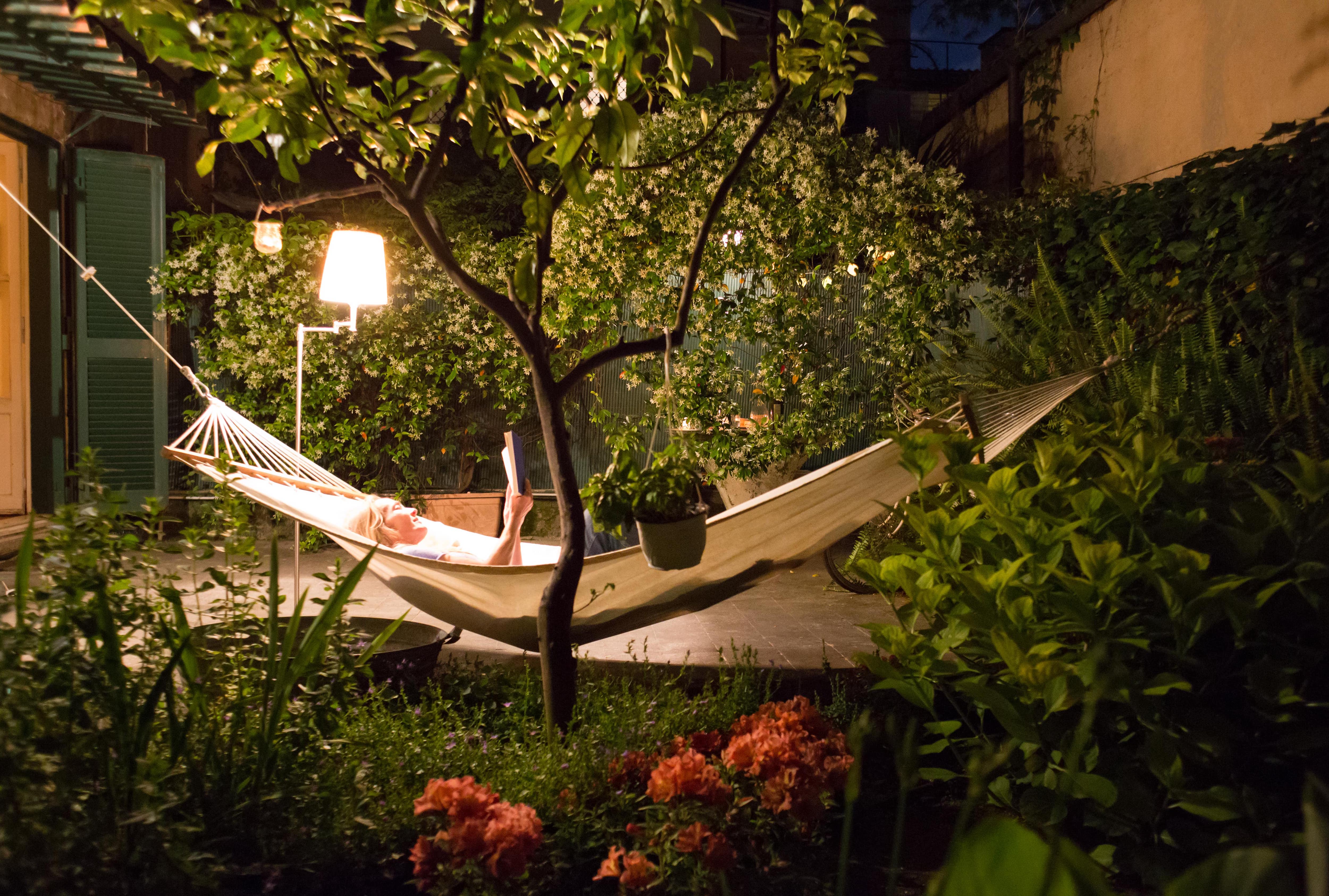 Woman reading a book on hammock at night