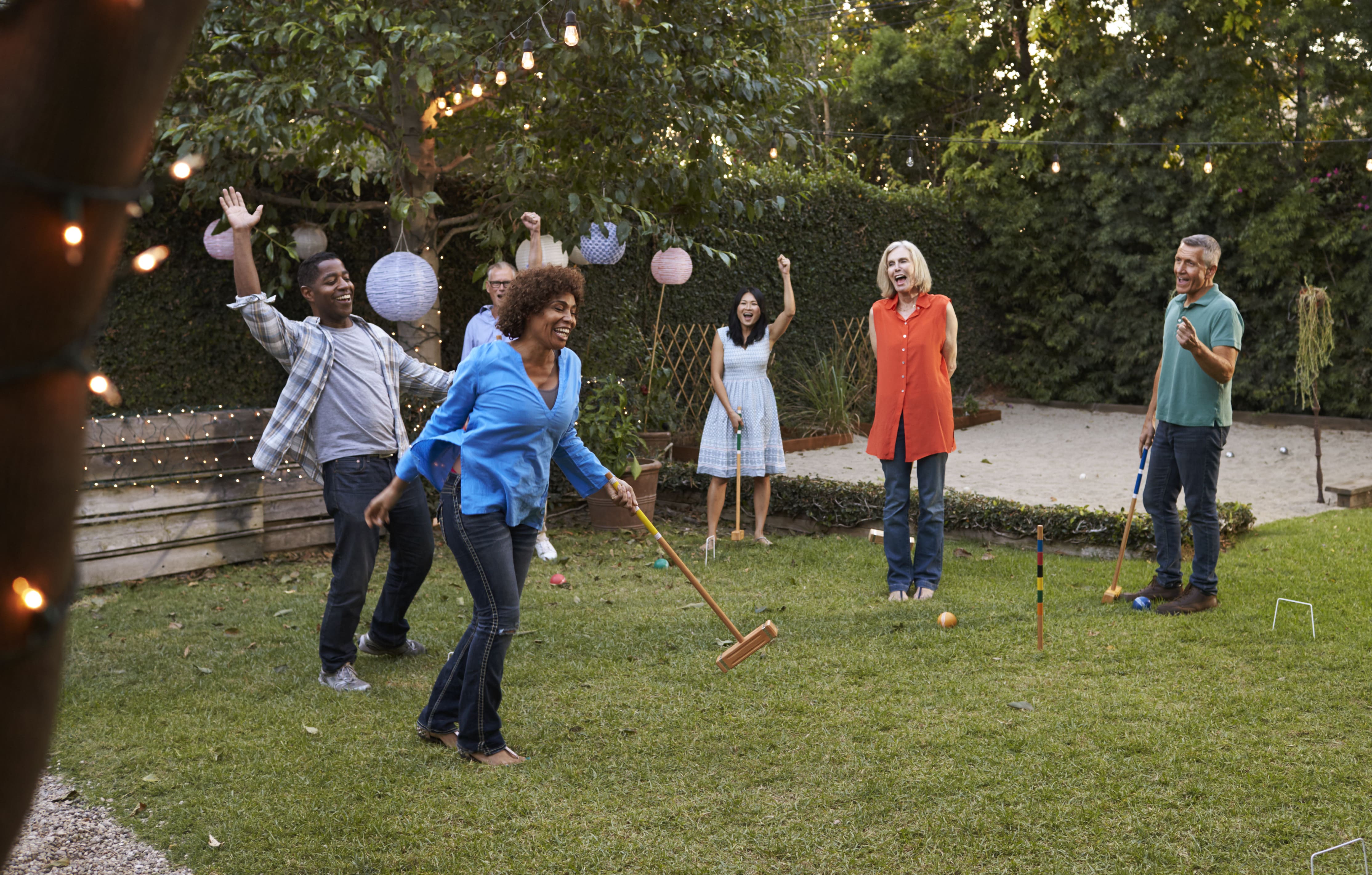 Friends playing croquet in backyard