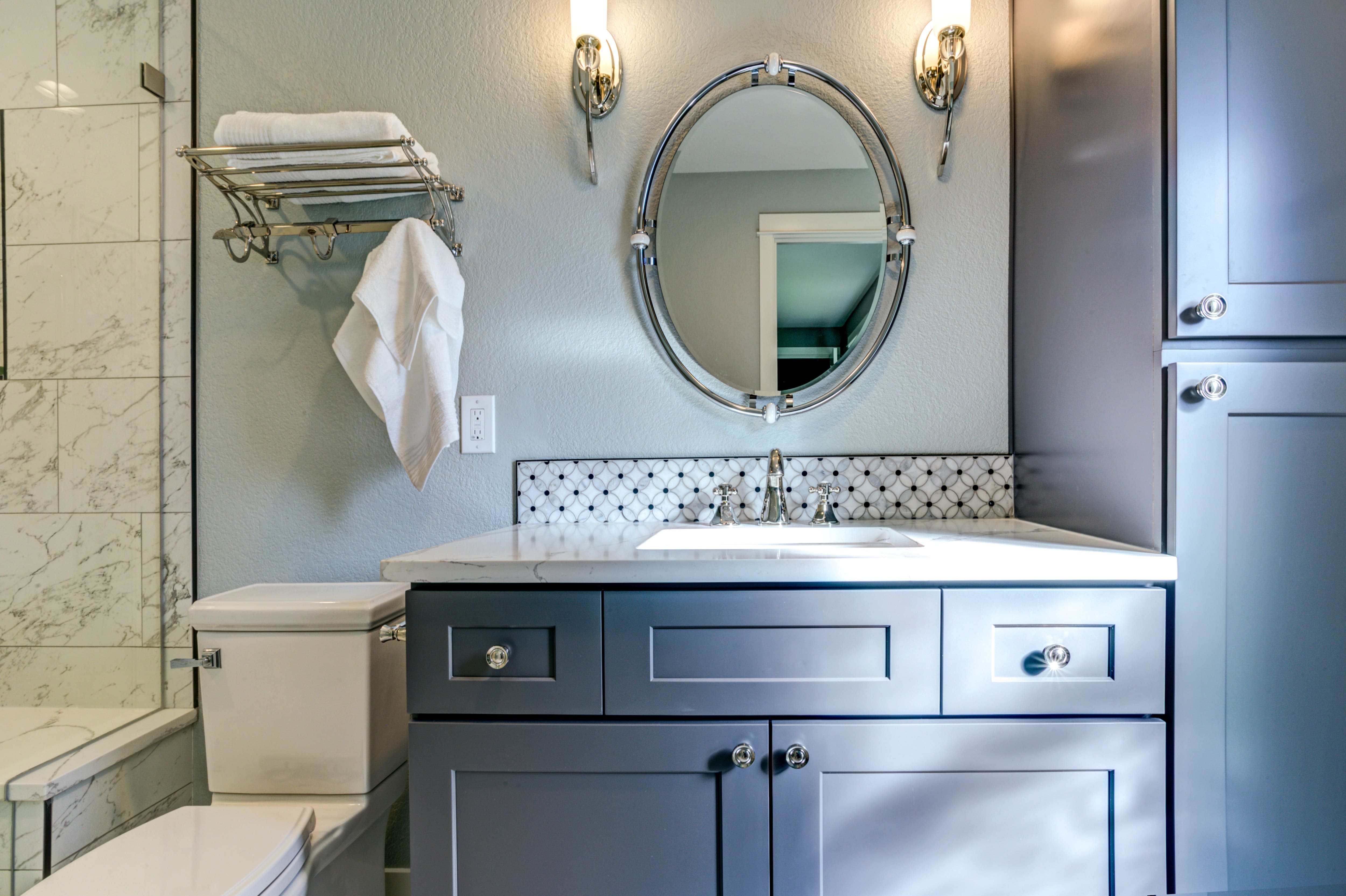 Blue gray vanity with mosaic tile backsplash in modern bathroom