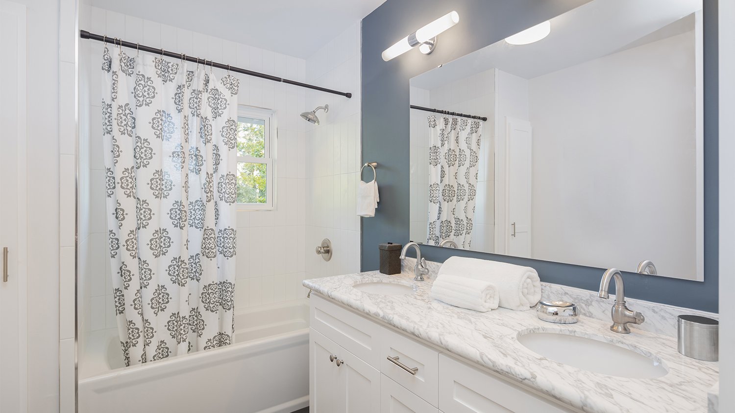 blue and white bathroom with large mirror