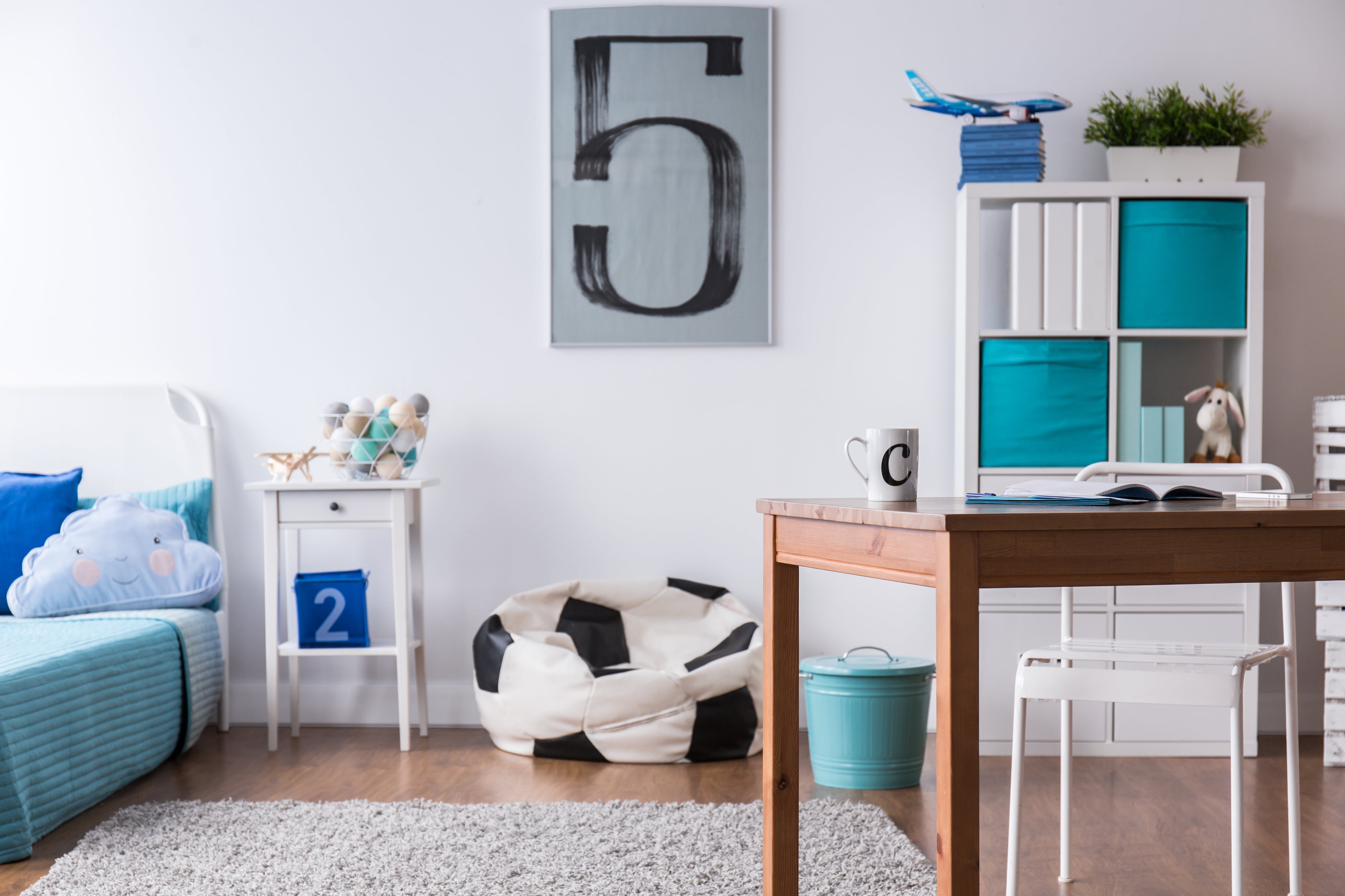 A kid's bedroom with a soccer ball print bean bag chair