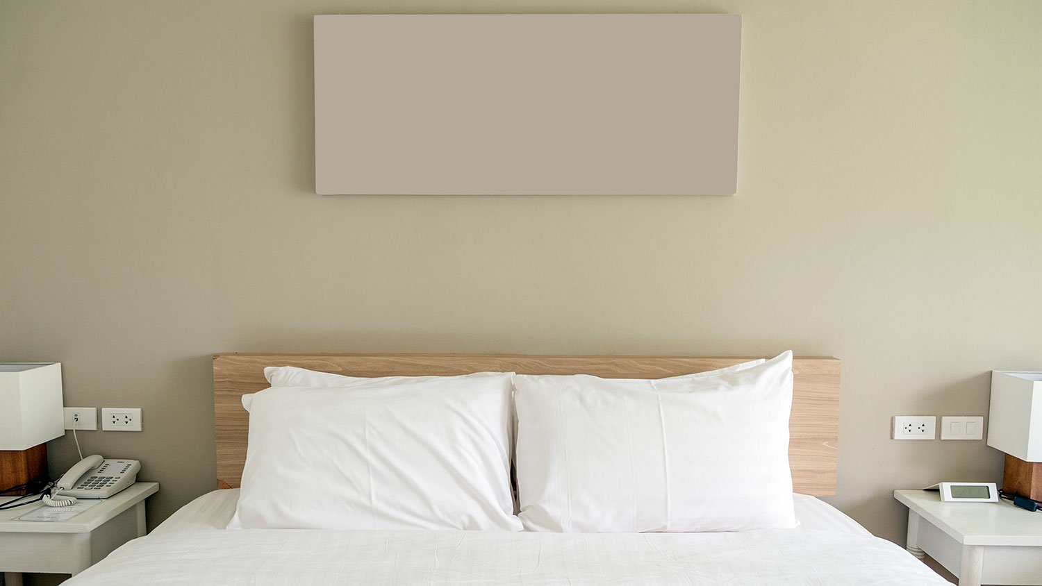 Bed with white linens and wooden headboard