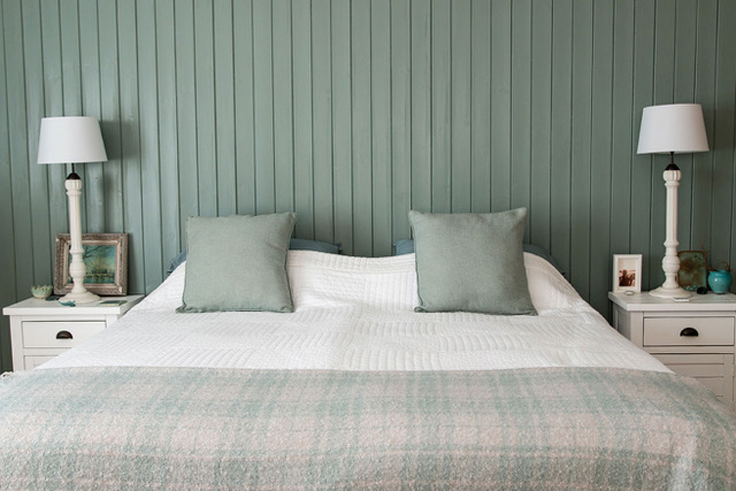 Bedroom with green accent wall and white furniture