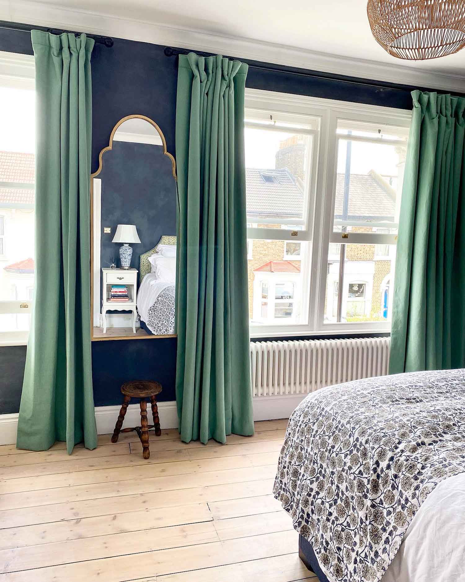 Bedroom with green curtains and blue wall