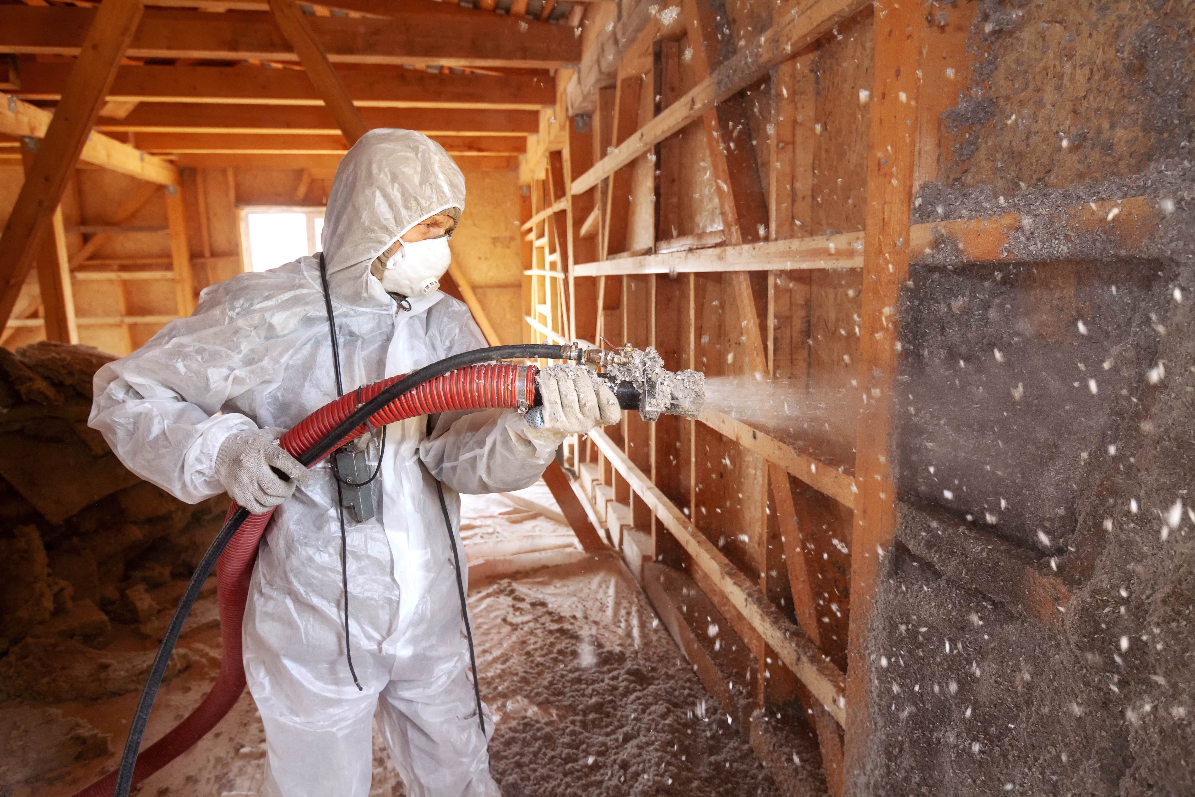 Cellulose insulation being installed on wall