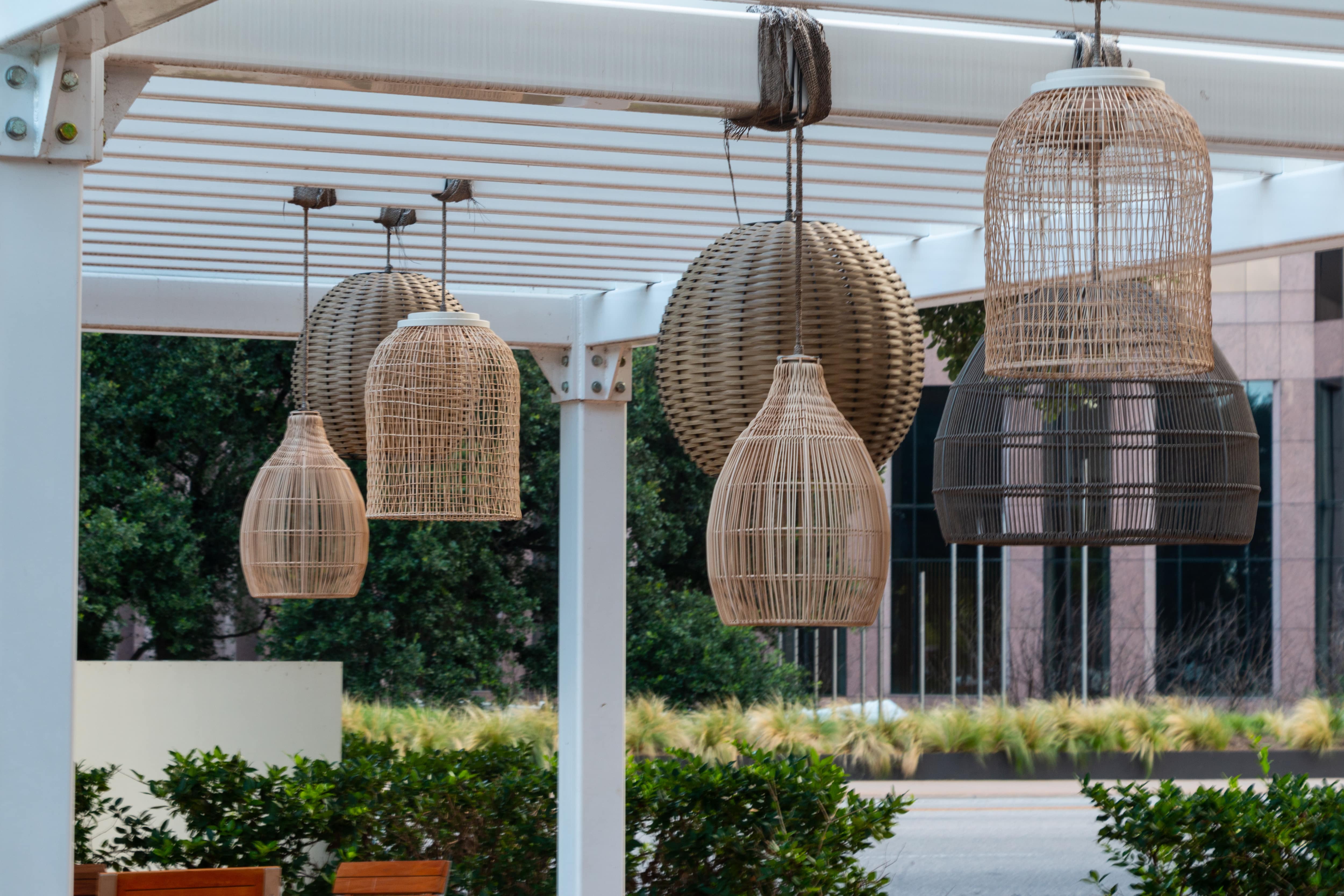 White pergola with seven woven lanterns in different shapes