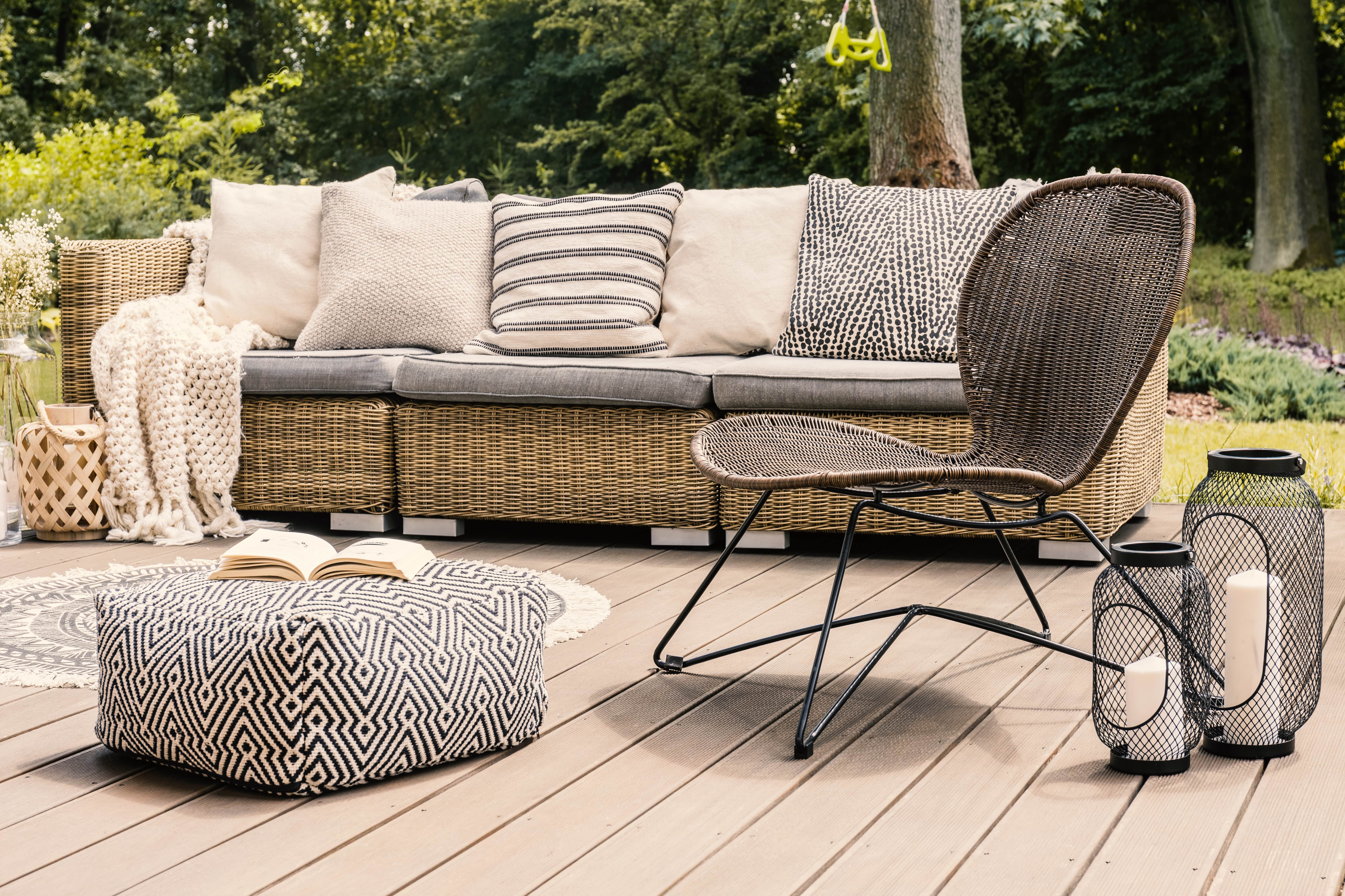 Outdoor couch and chair with patterned pillows and pouf