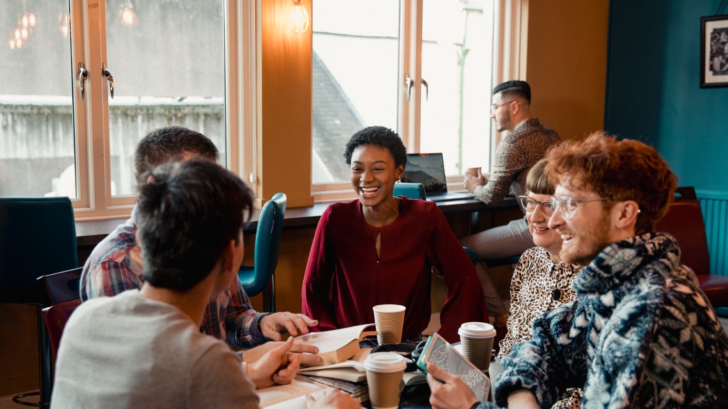 people in bookclub sitting around table in coffee shop