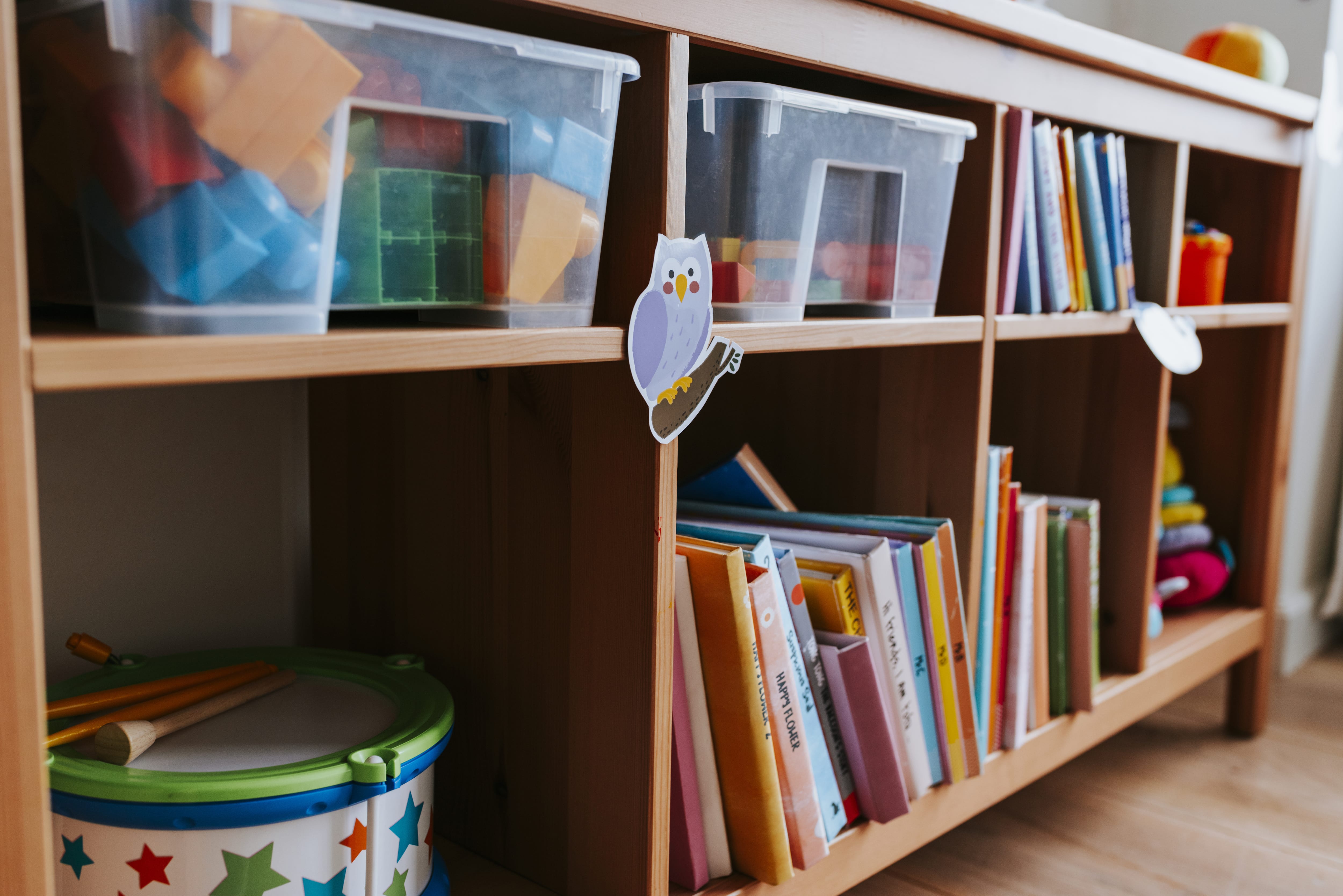 A kids playroom with a short bookshelf