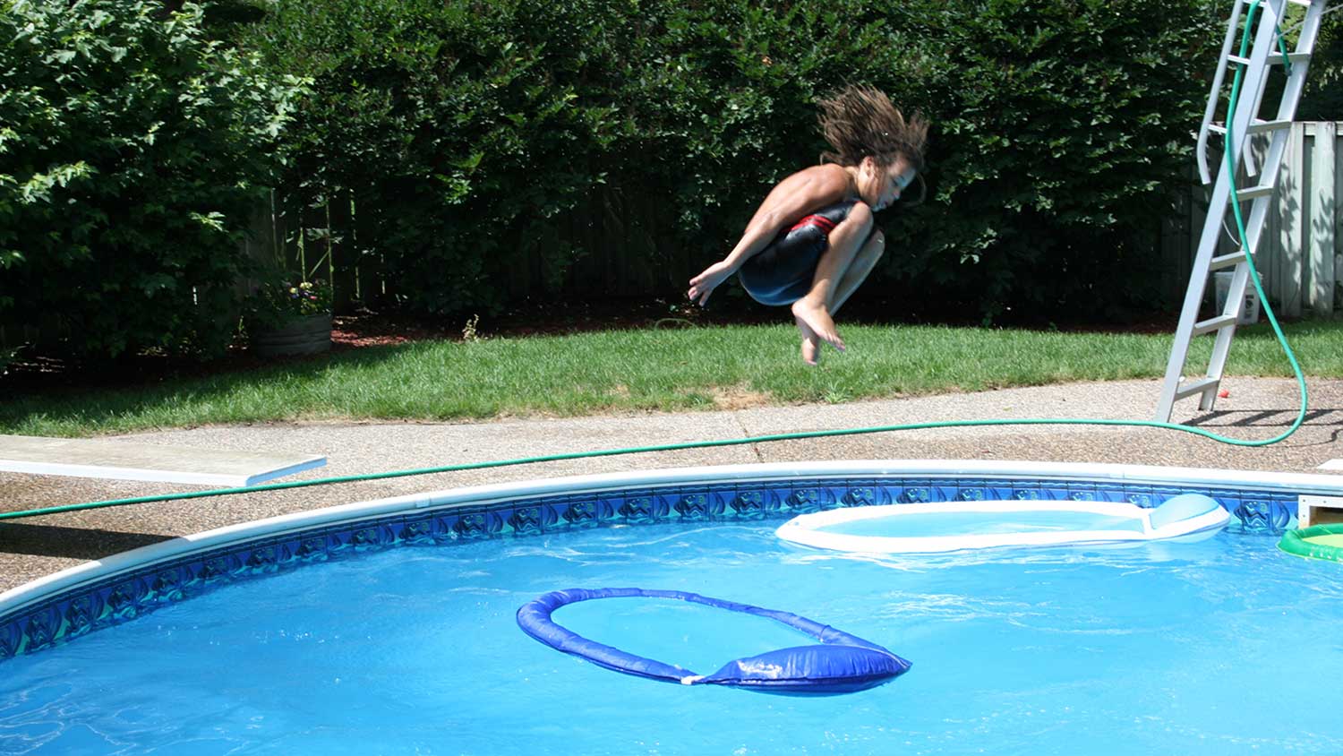Boy jumping into swimming pool