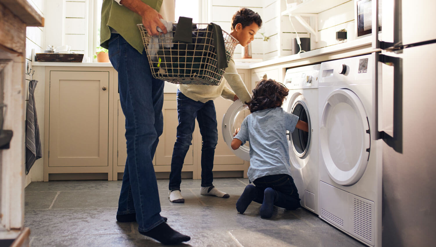 Two boys along their father doing the laundry