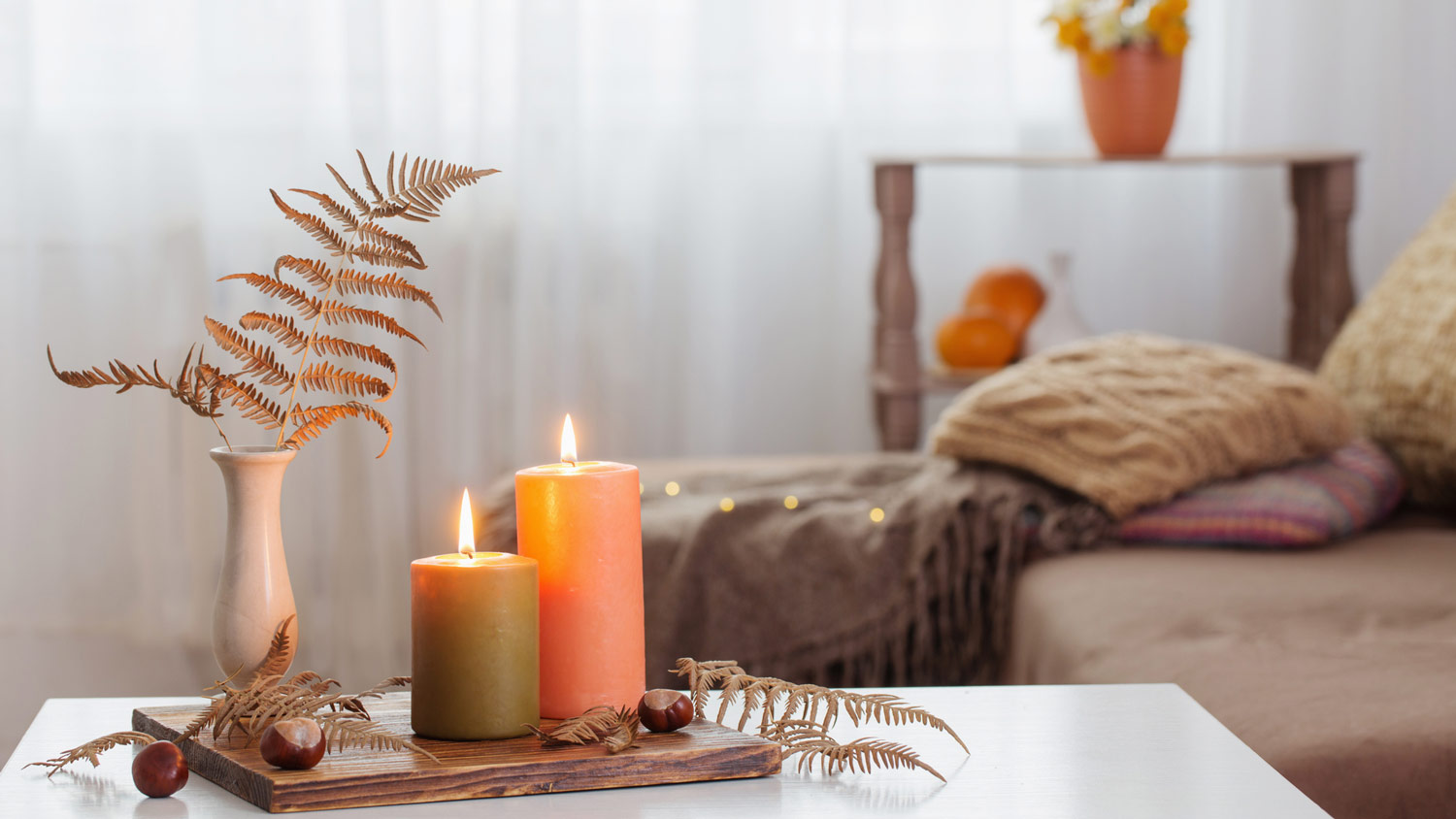 Candles with autumn decor on a coffee table