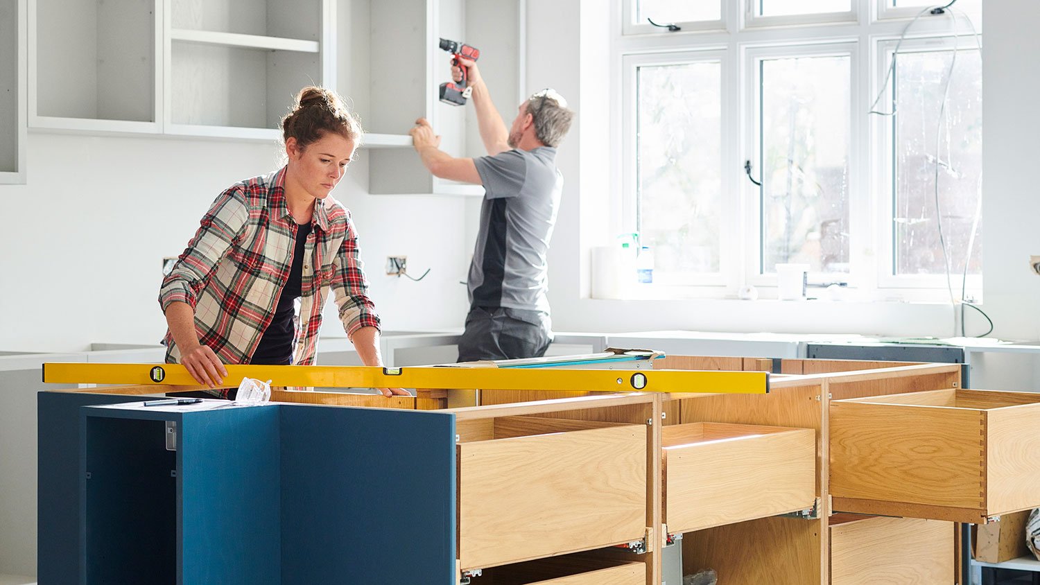 Carpenters installing kitchen island and cabinets