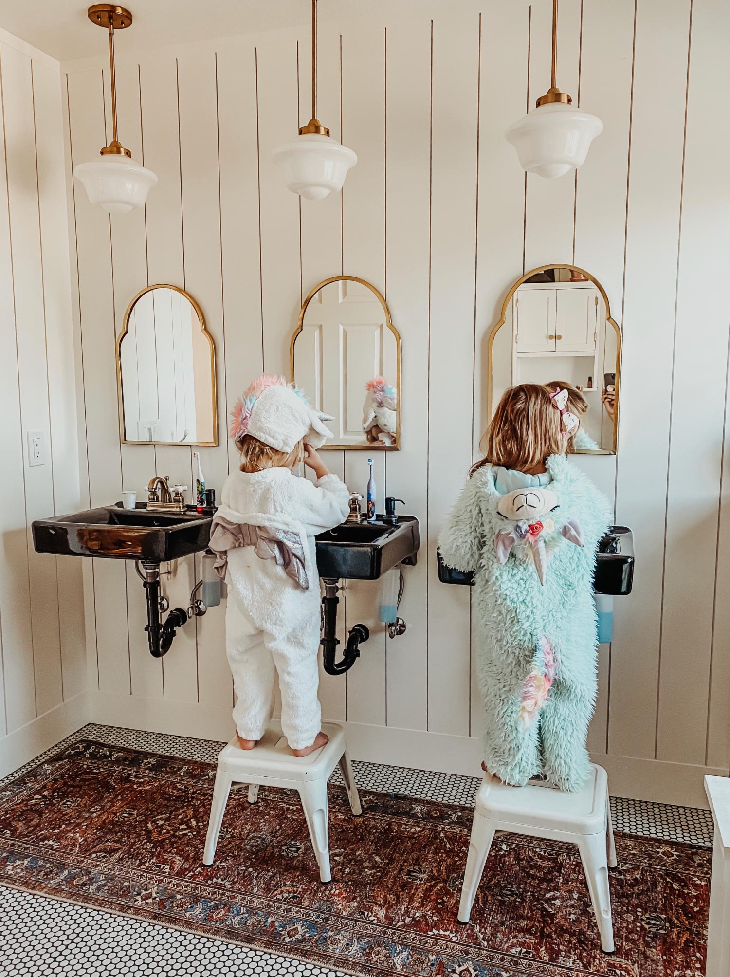 Young children brushing their teeth in a mirror