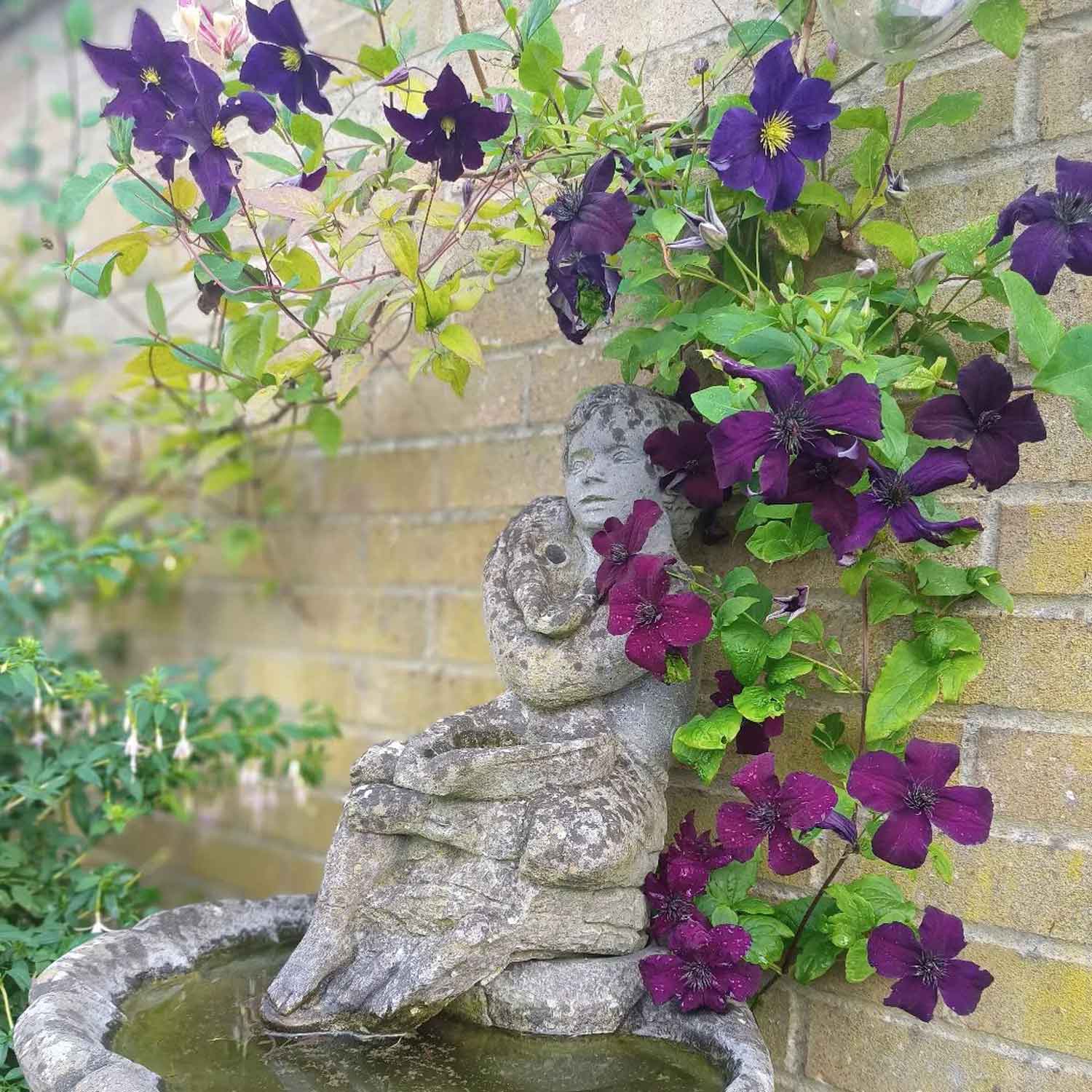 Classic garden statue surrounded by flowers