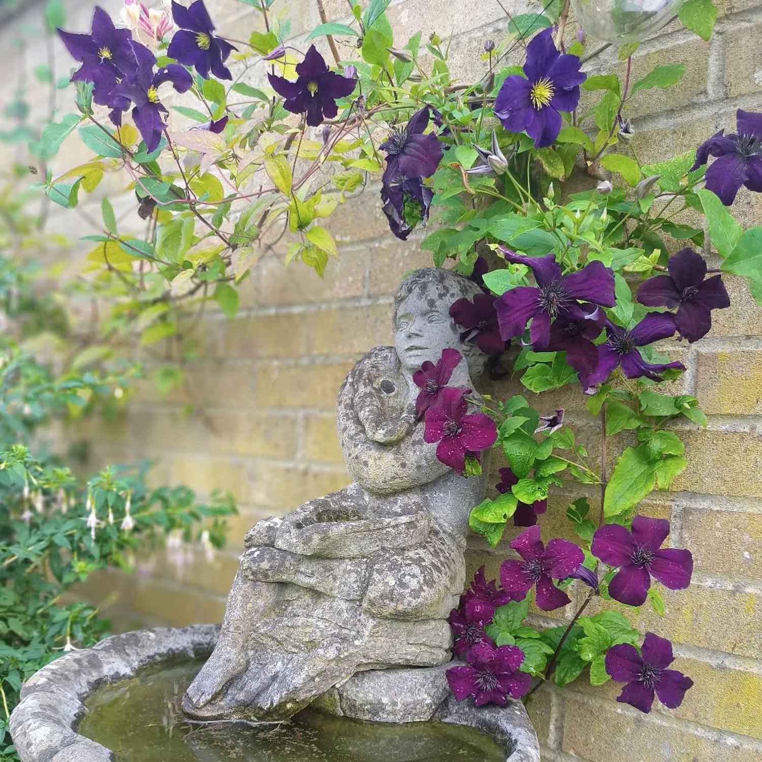 Classic garden statue surrounded by flowers 