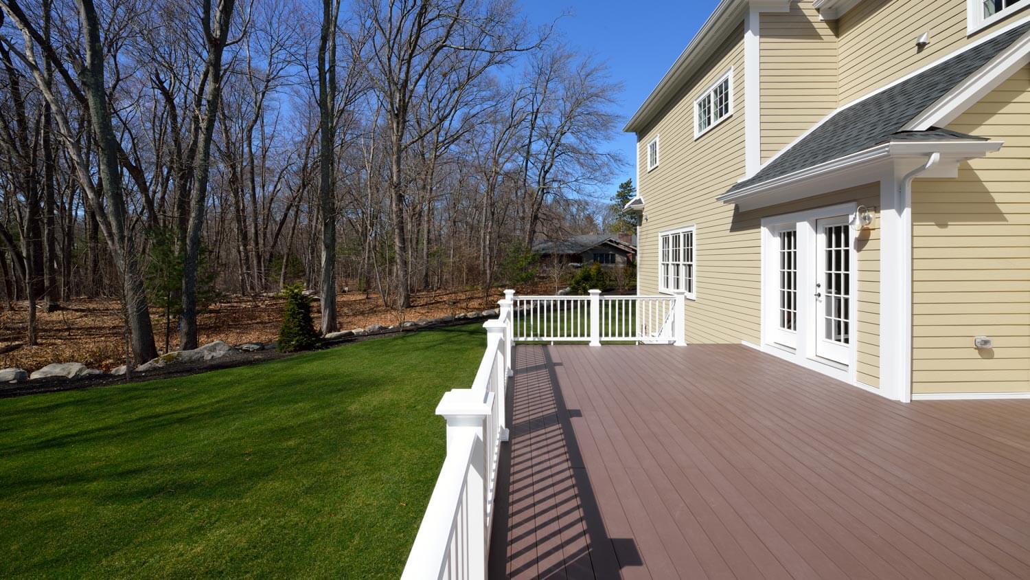 A composite decking in the backyard of a colonial style house