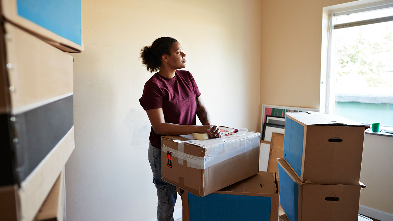 Contemplative woman with moving boxes