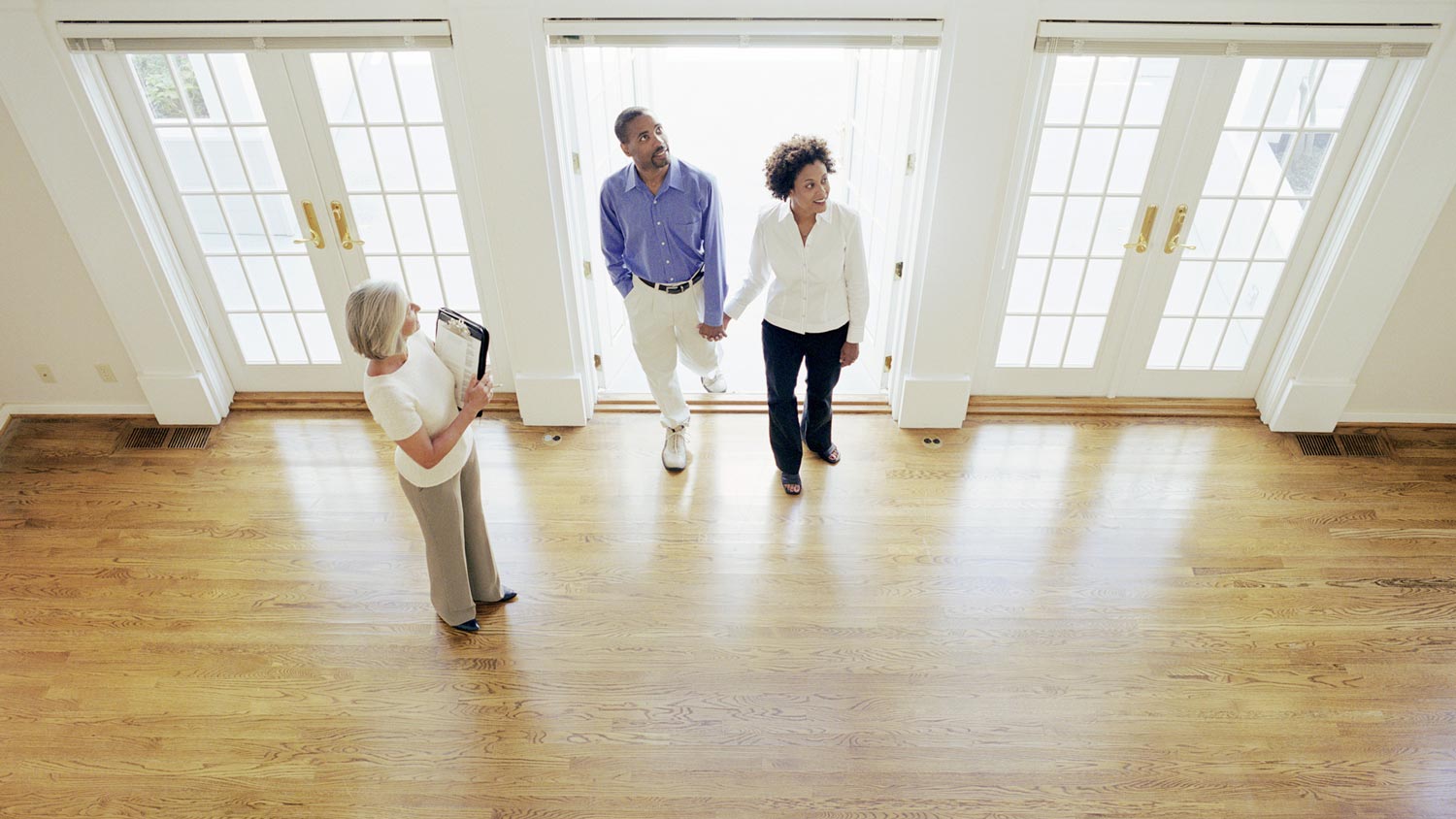 A mature realtor opening a potential house to a couple