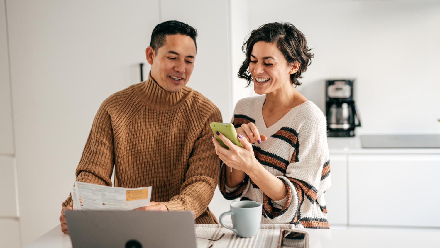 A couple in the kitchen with bills