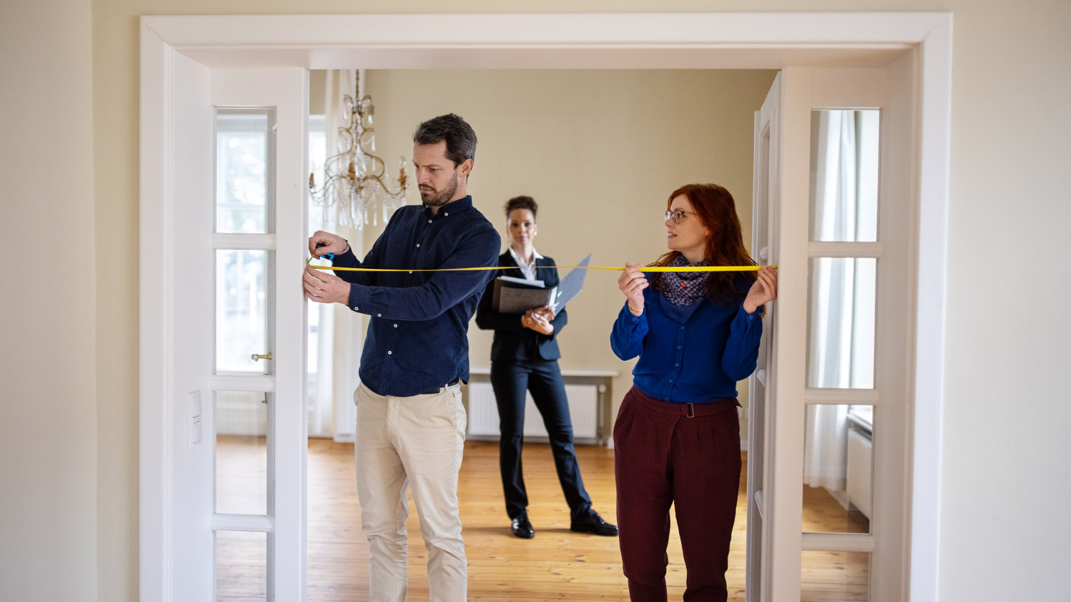 Couple measuring doorway in house