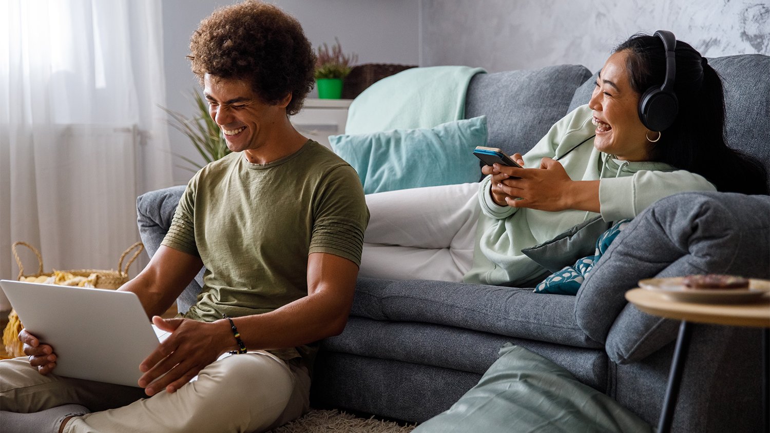 couple hanging out in the living room while on the phone and computer