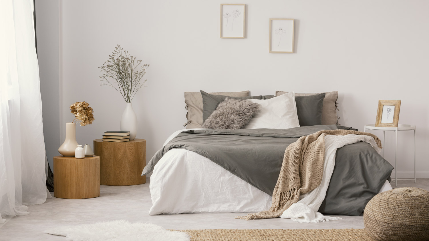 A cozy bedroom with area rugs on the hardwood floor