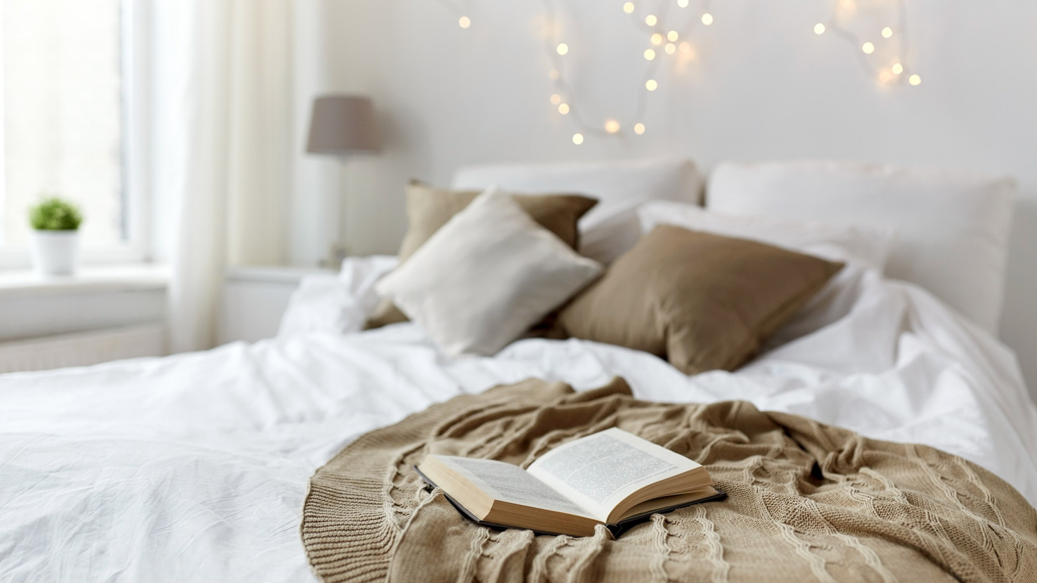 A cozy bedroom with lights hanging from the wall