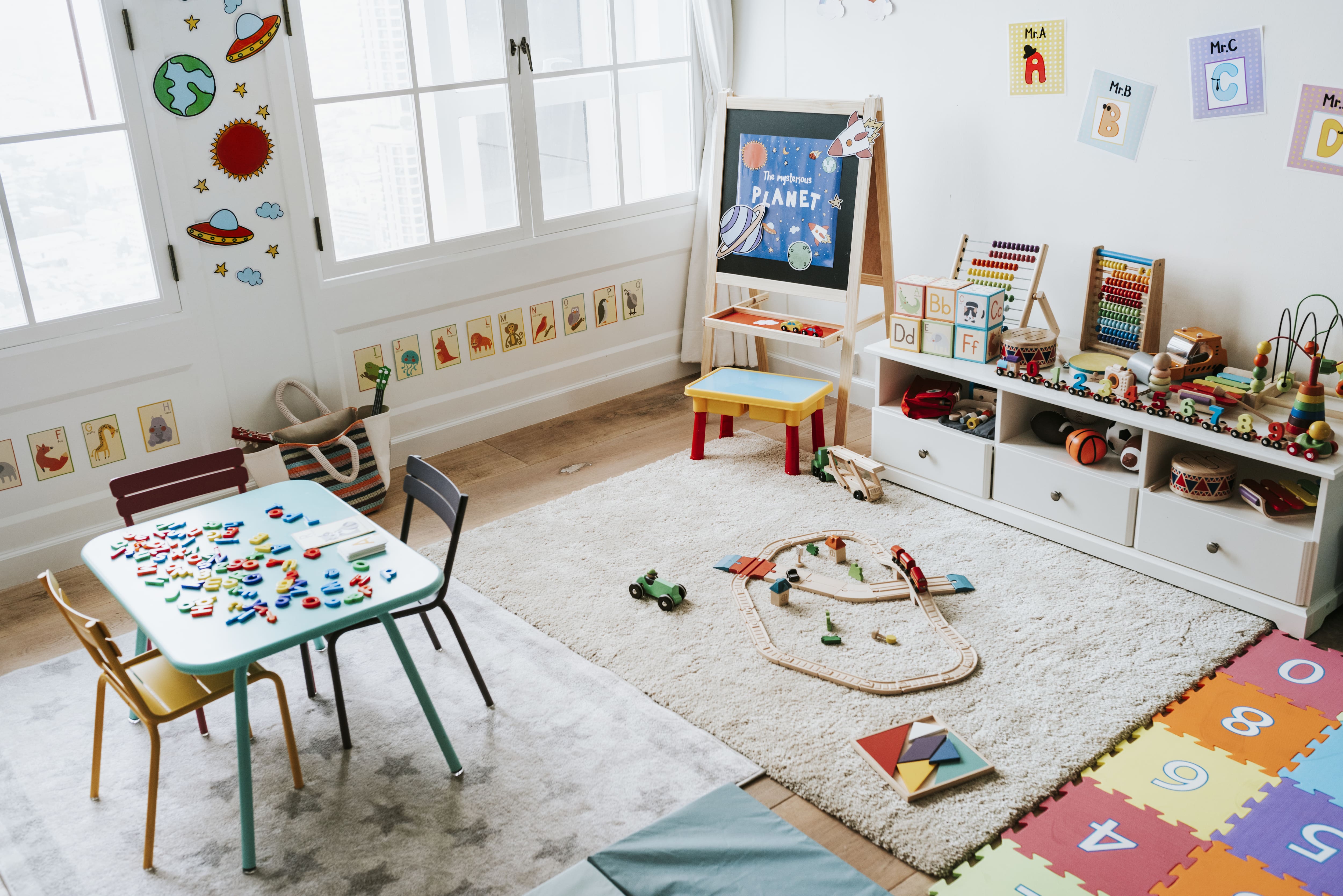 A kids' room with toys, a chalk easel, and a play table with chairs