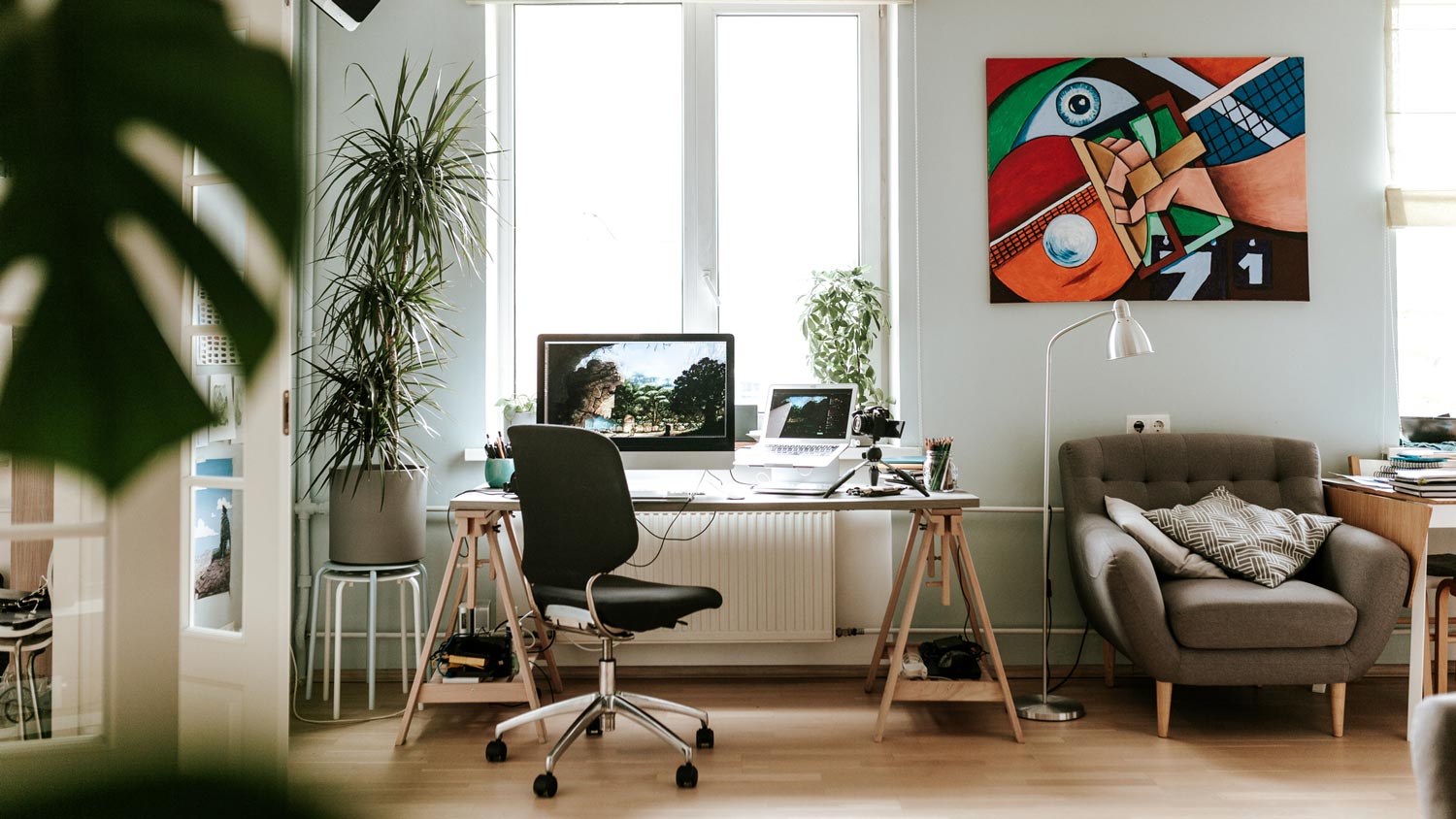 A creative home office with plants surrounding the desk