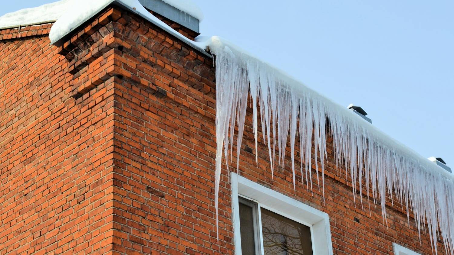 Dangerous ice dams on a red brick house